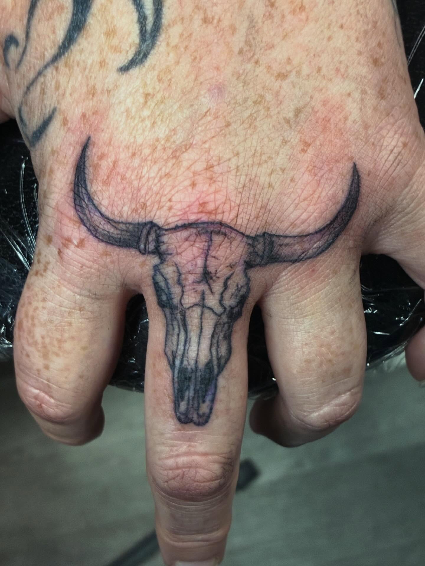 Bull skull black and grey tattoo on the hand by Trae
