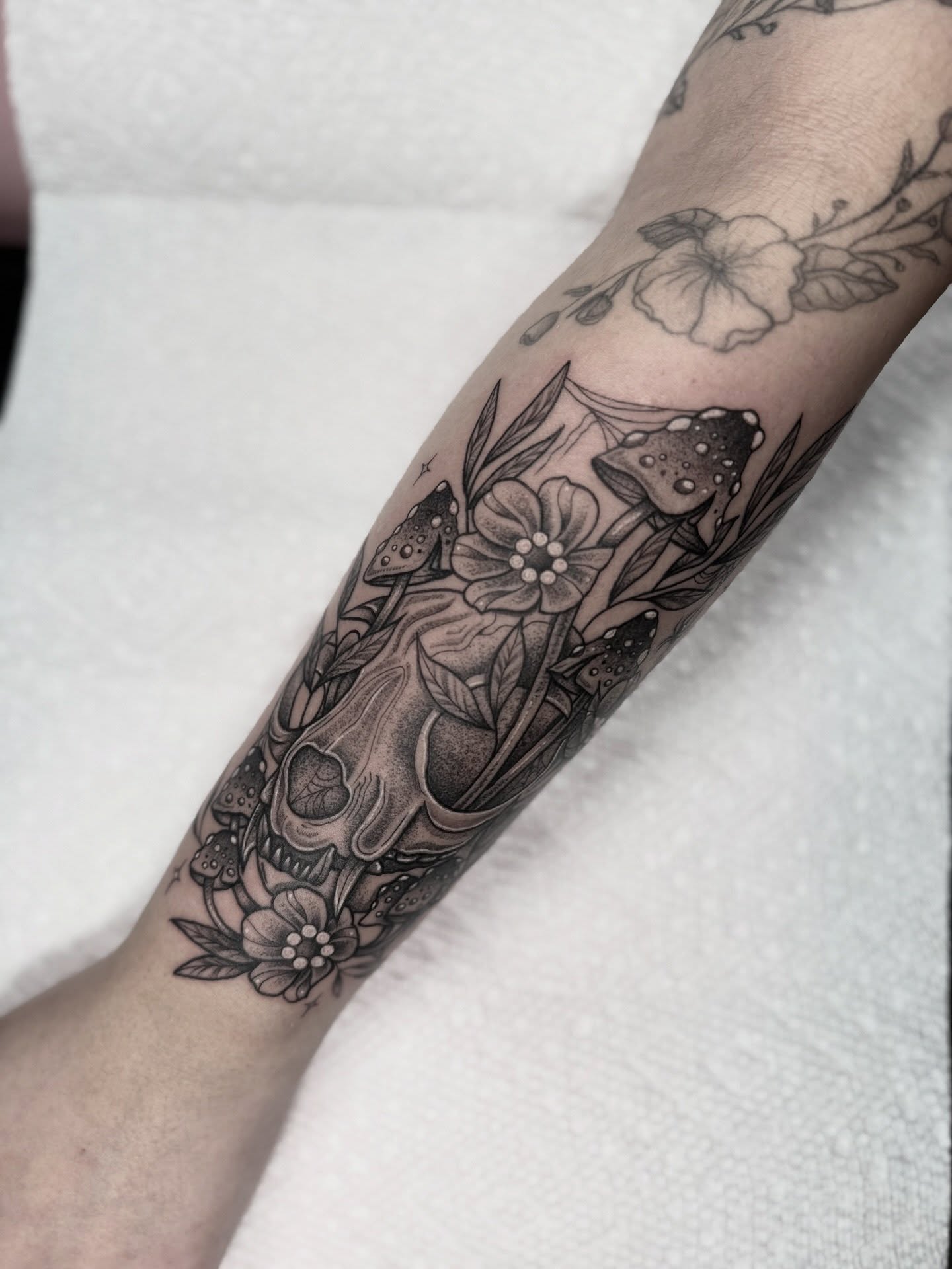 Skull and flowers dotwork tattoo on the forearm by Mara Flores βπΛβ§