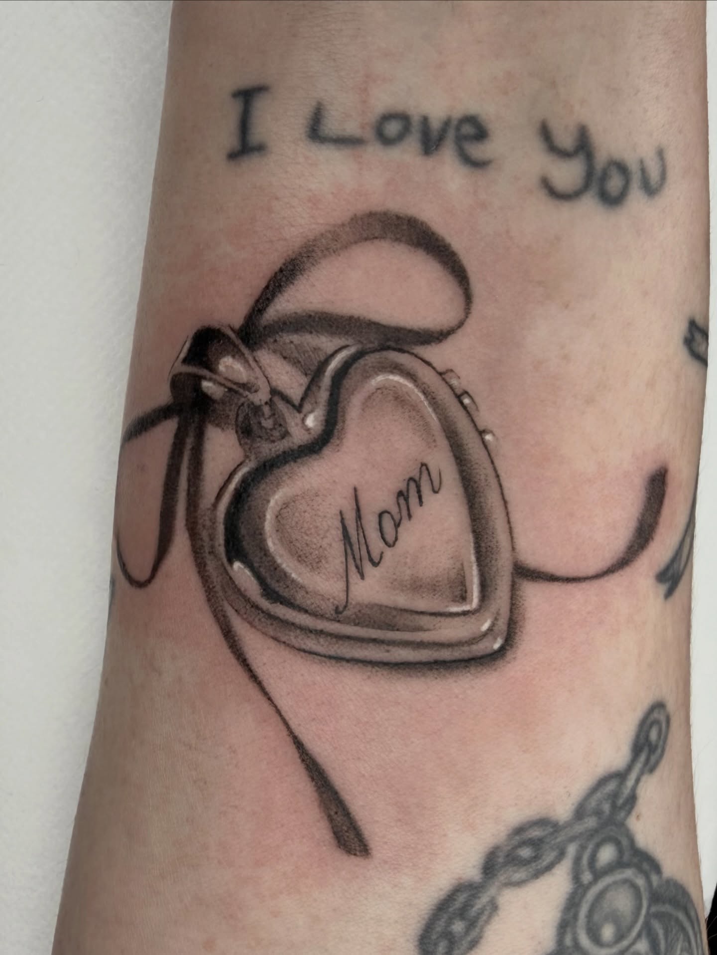 Heart locket black and grey tattoo on the forearm by Red
