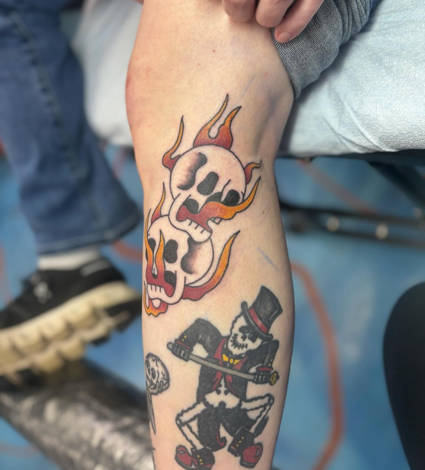 Skulls and skeleton American traditional tattoo on the forearm by Cam Sykes