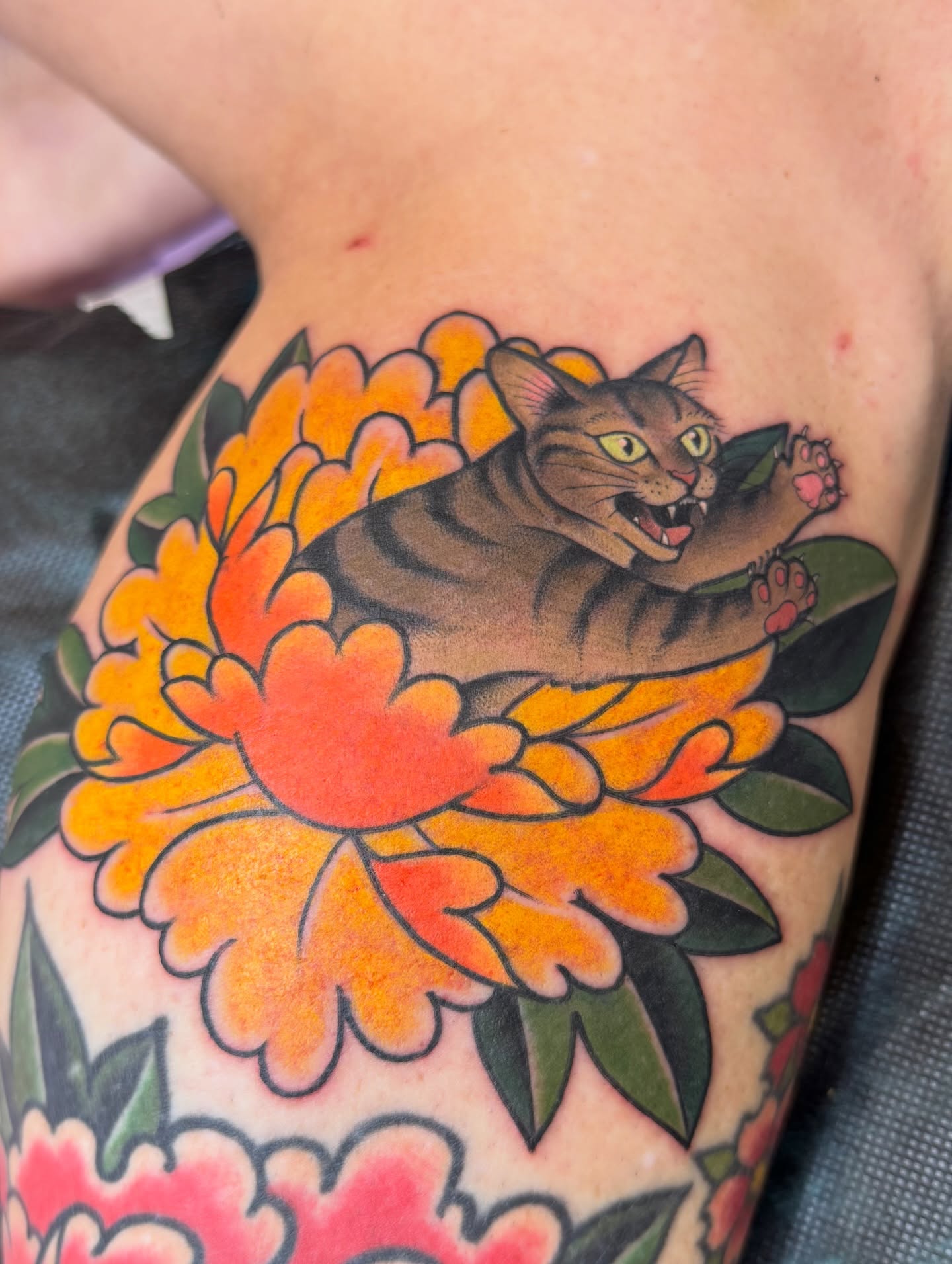 Cat and flowers American traditional tattoo on the thigh by Anna Wall