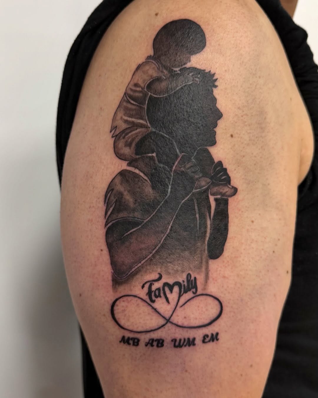 Family silhouette black and grey tattoo on the shoulder by Bailee