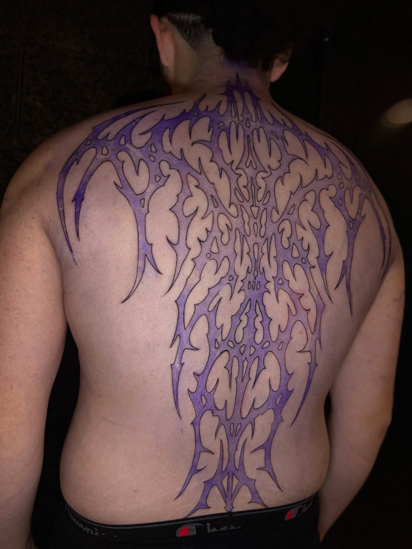 Flame pattern geometric tattoo on the back by Thomas Martinez