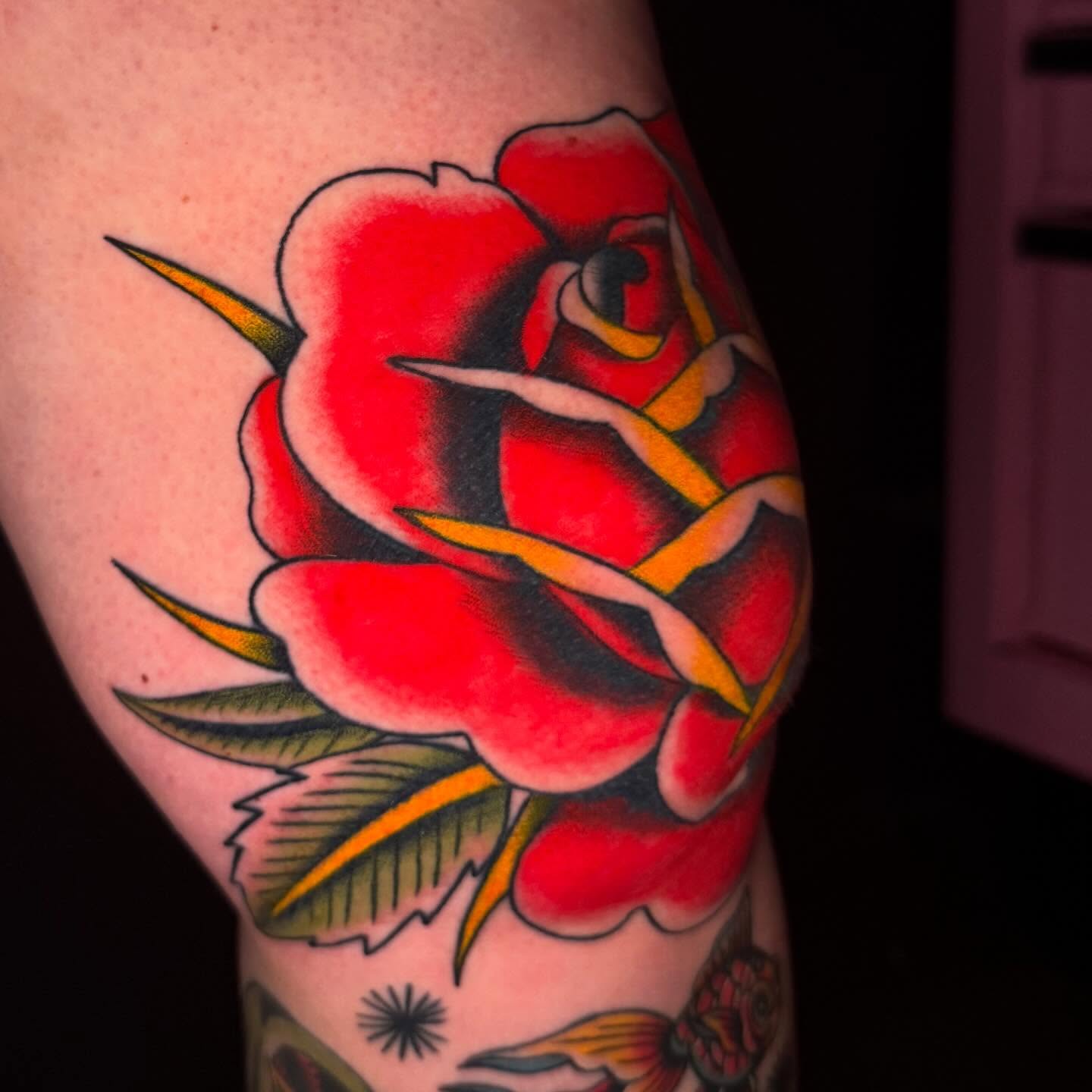 Red rose American traditional tattoo on the forearm by Mallory Brown