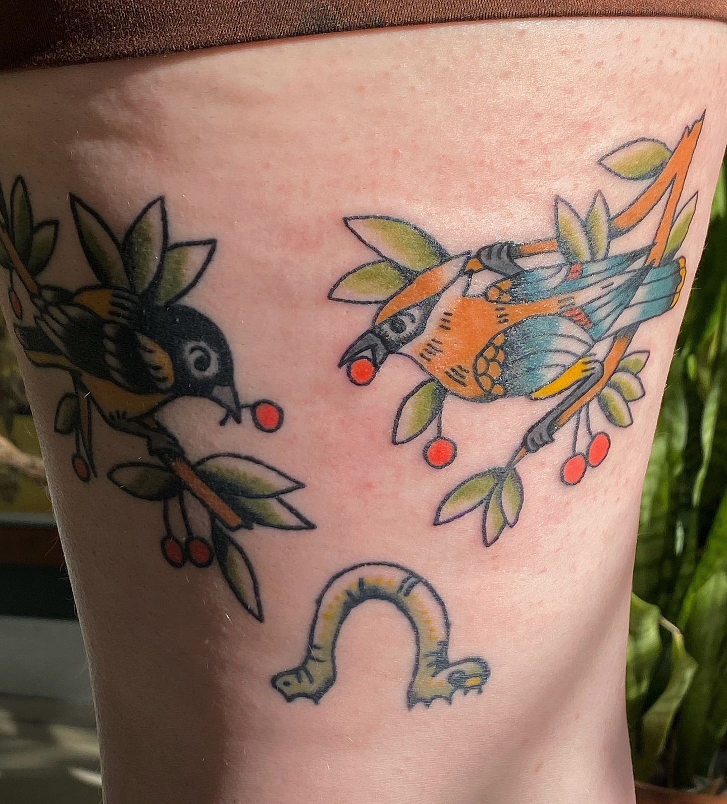 Birds and worm American traditional tattoo on the thigh by Corinne Carter