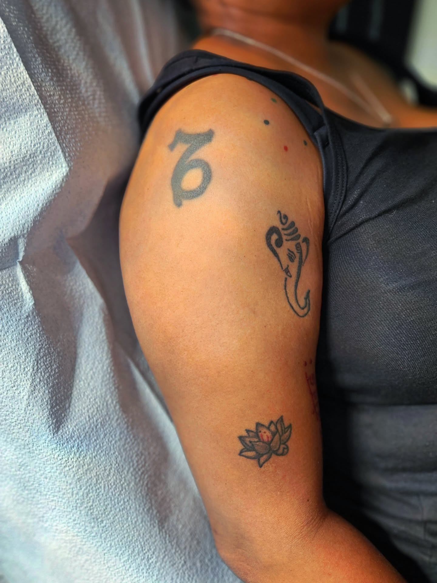 Lotus flower black and grey tattoo on the upper arm by ๐๐๐๐