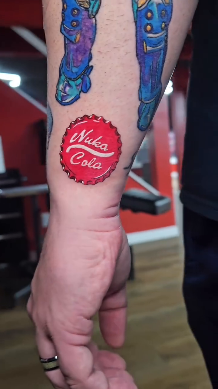 Nuka-Cola bottle cap and robot legs new school tattoo on the forearm by John Briceño, Columbus, Ohio