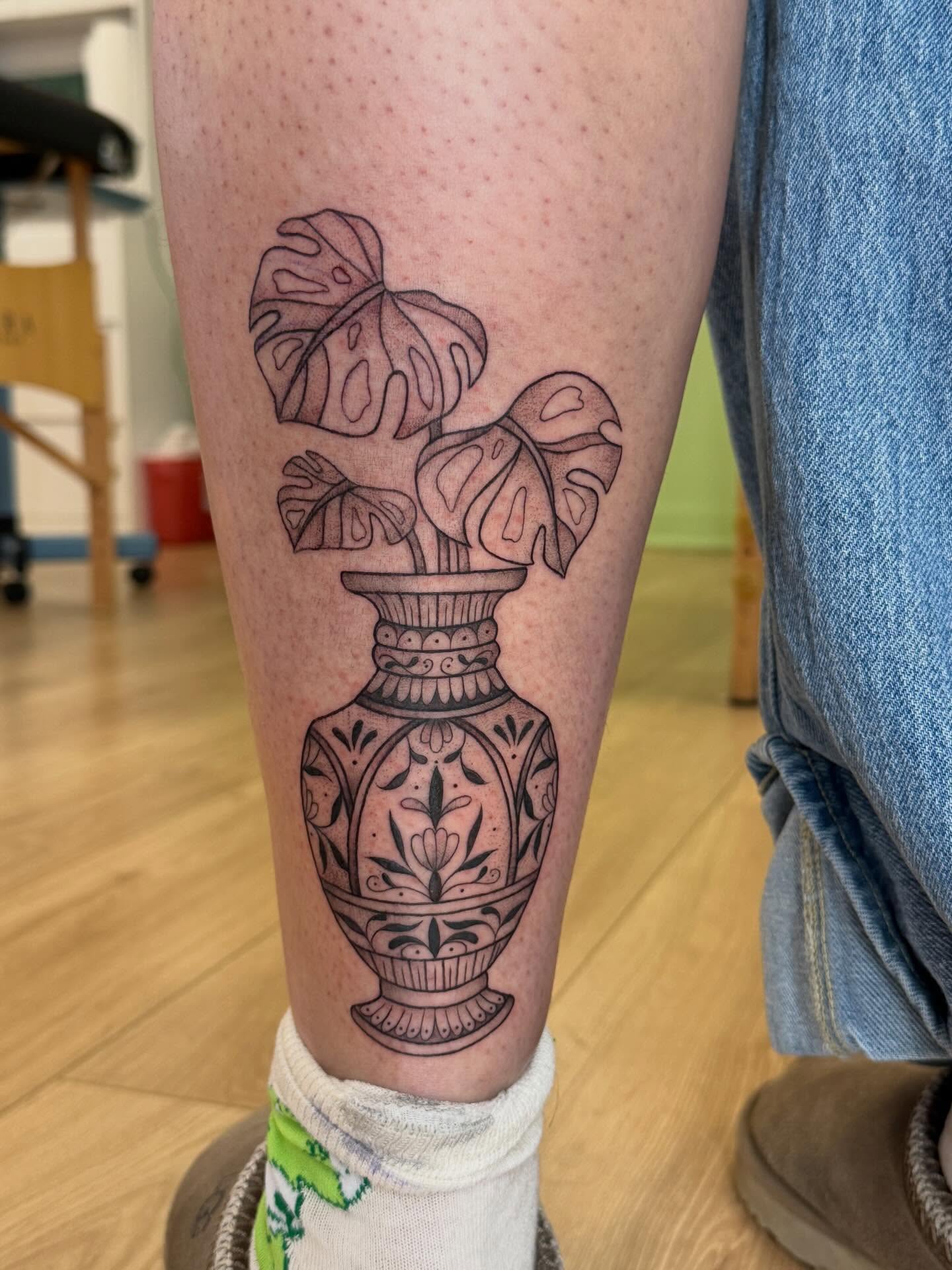 Vase with monstera leaves black and grey tattoo on the calf by Rachel ˚⊱🪷⊰˚ 芷若, Des Moines, Iowa