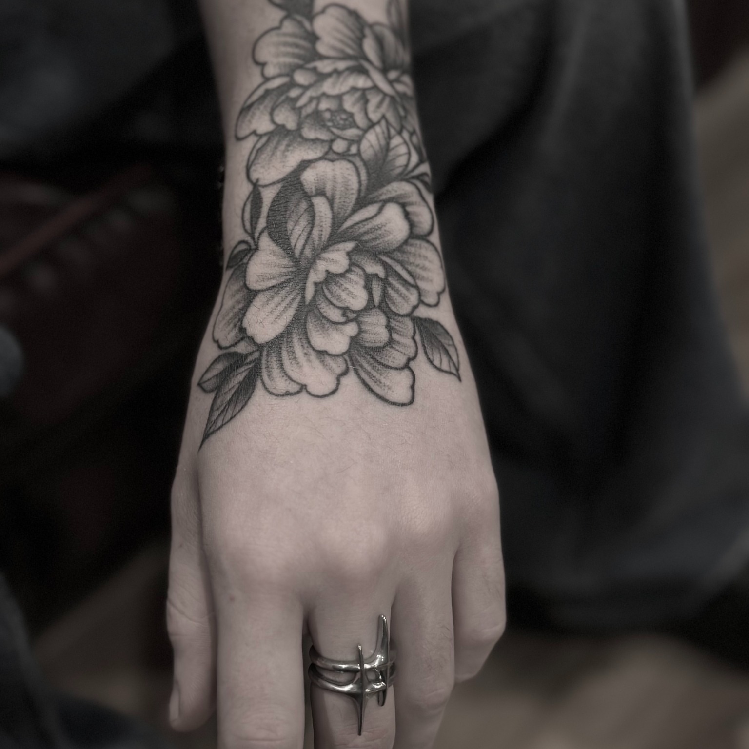 Floral arrangement black and grey tattoo on the forearm by Tattoos By Josh