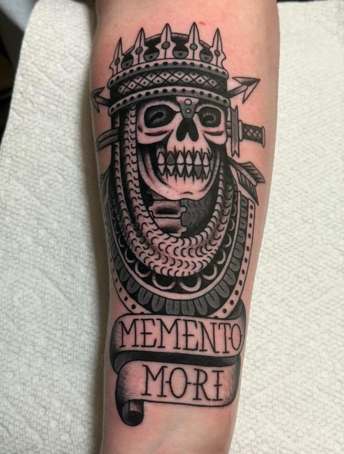 Skull with crown black and grey tattoo on the forearm by Brandon Bear