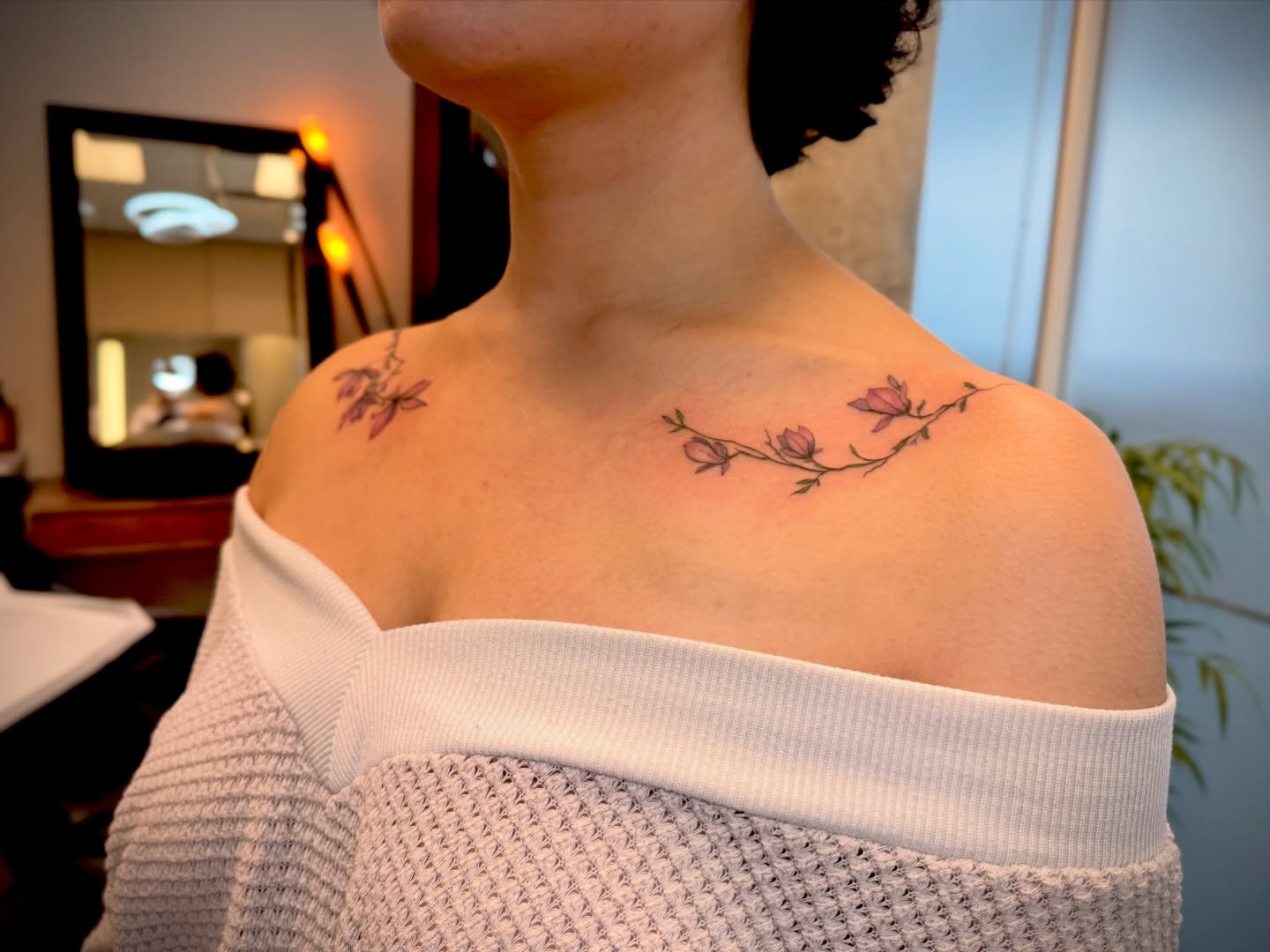 Flower branch fine line tattoo on the shoulder by Aristova Anastasia