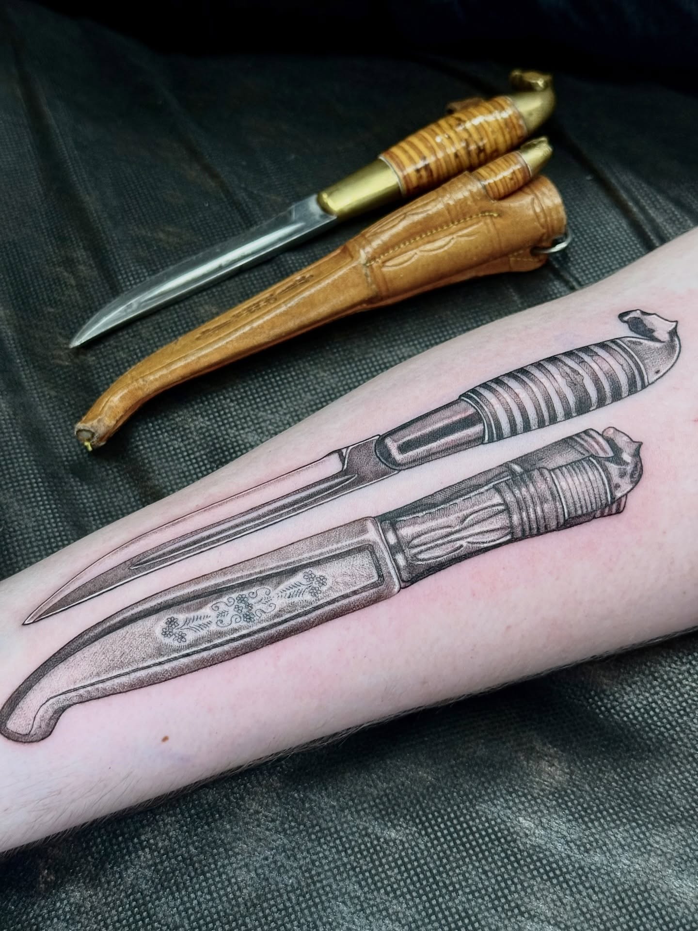 Knives black and grey tattoo on the forearm by Lydia Jude