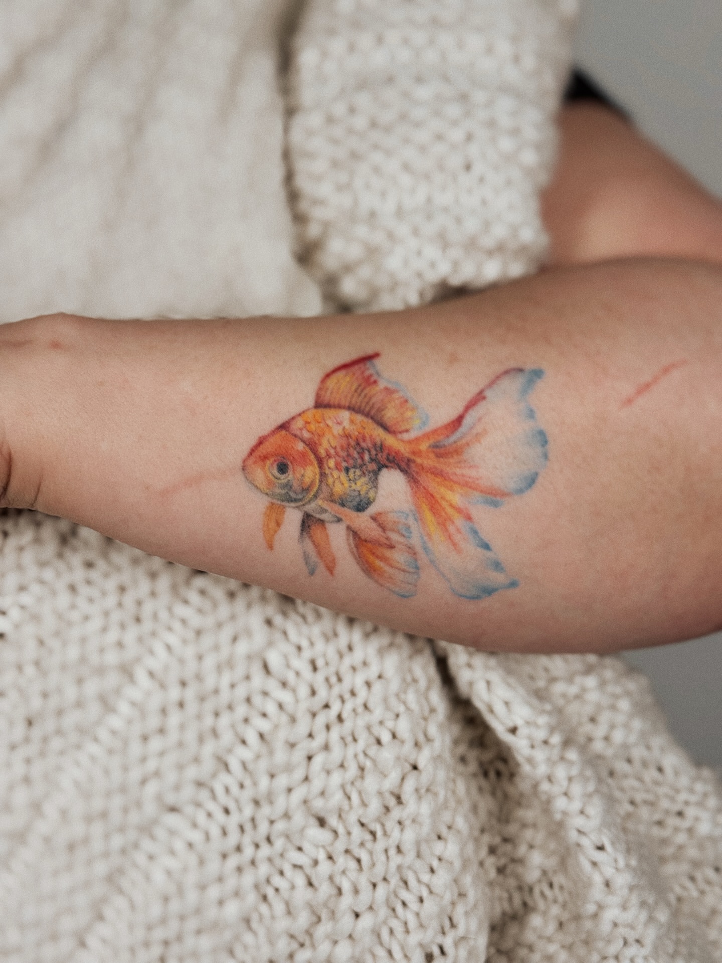 Goldfish watercolor tattoo on the forearm by Andrea Evangelista