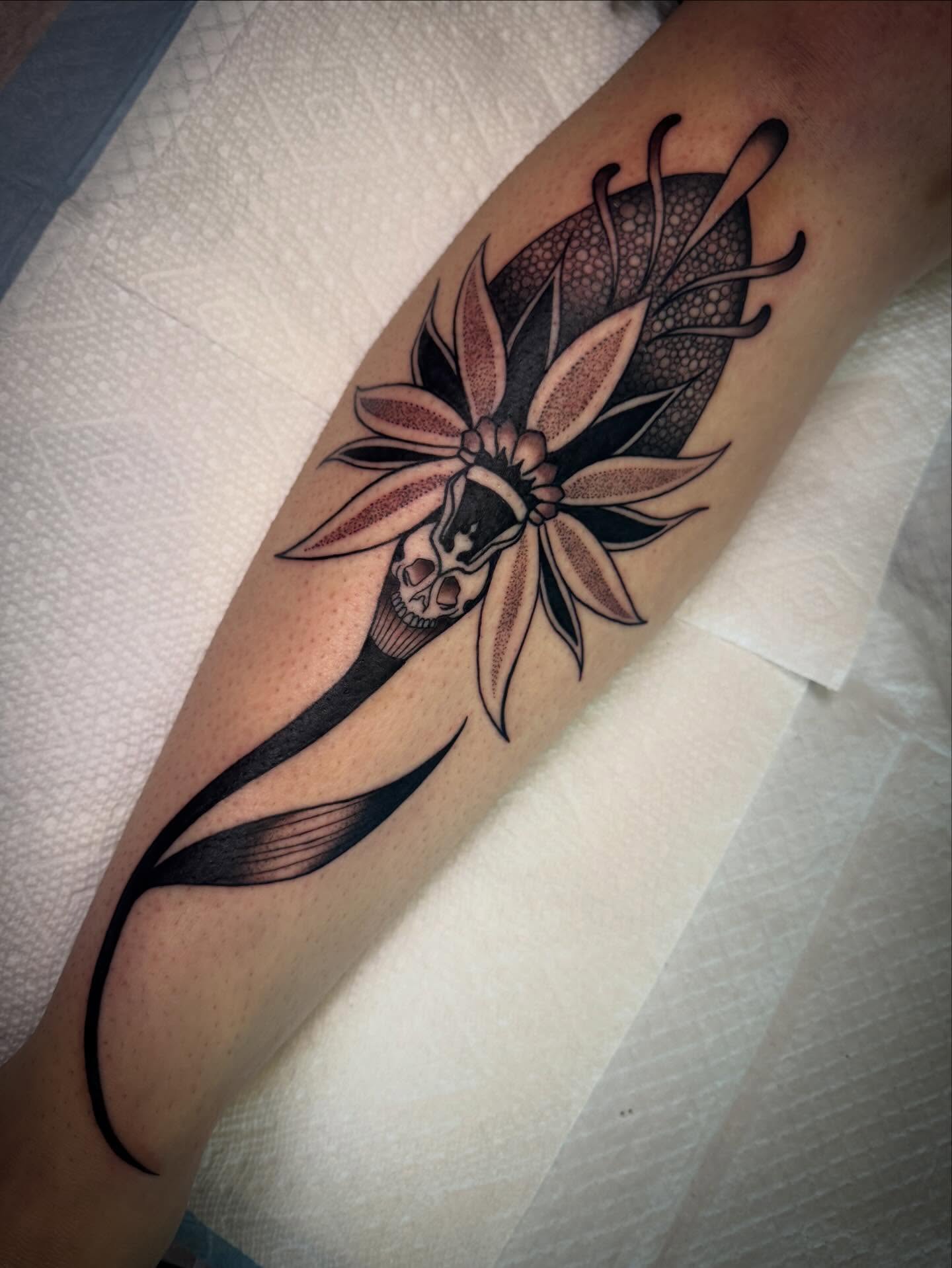 Lotus flower with skull realism tattoo on the forearm by Paul Giovis