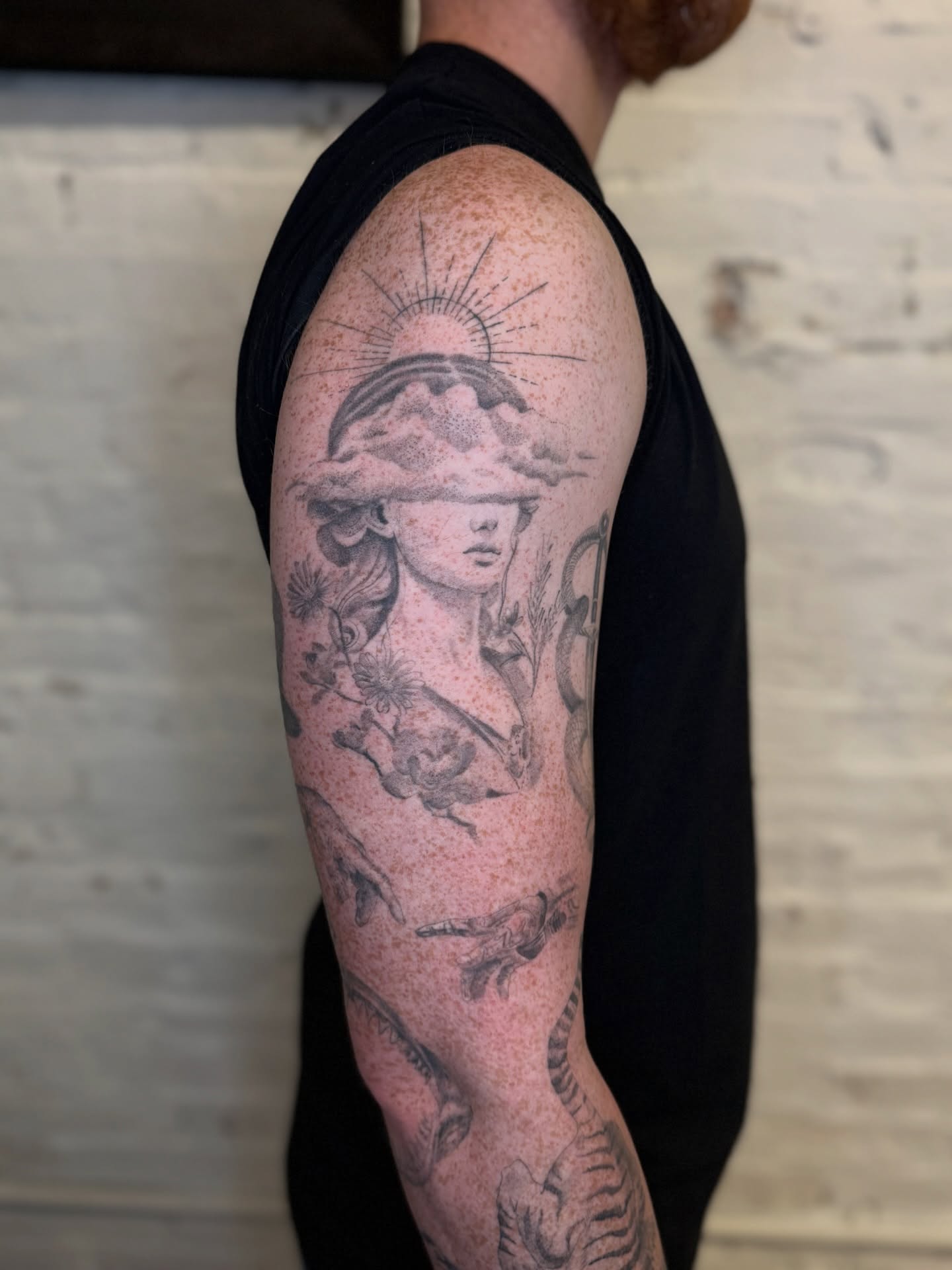 Woman with hat realism tattoo on the upper arm by Josh Infante