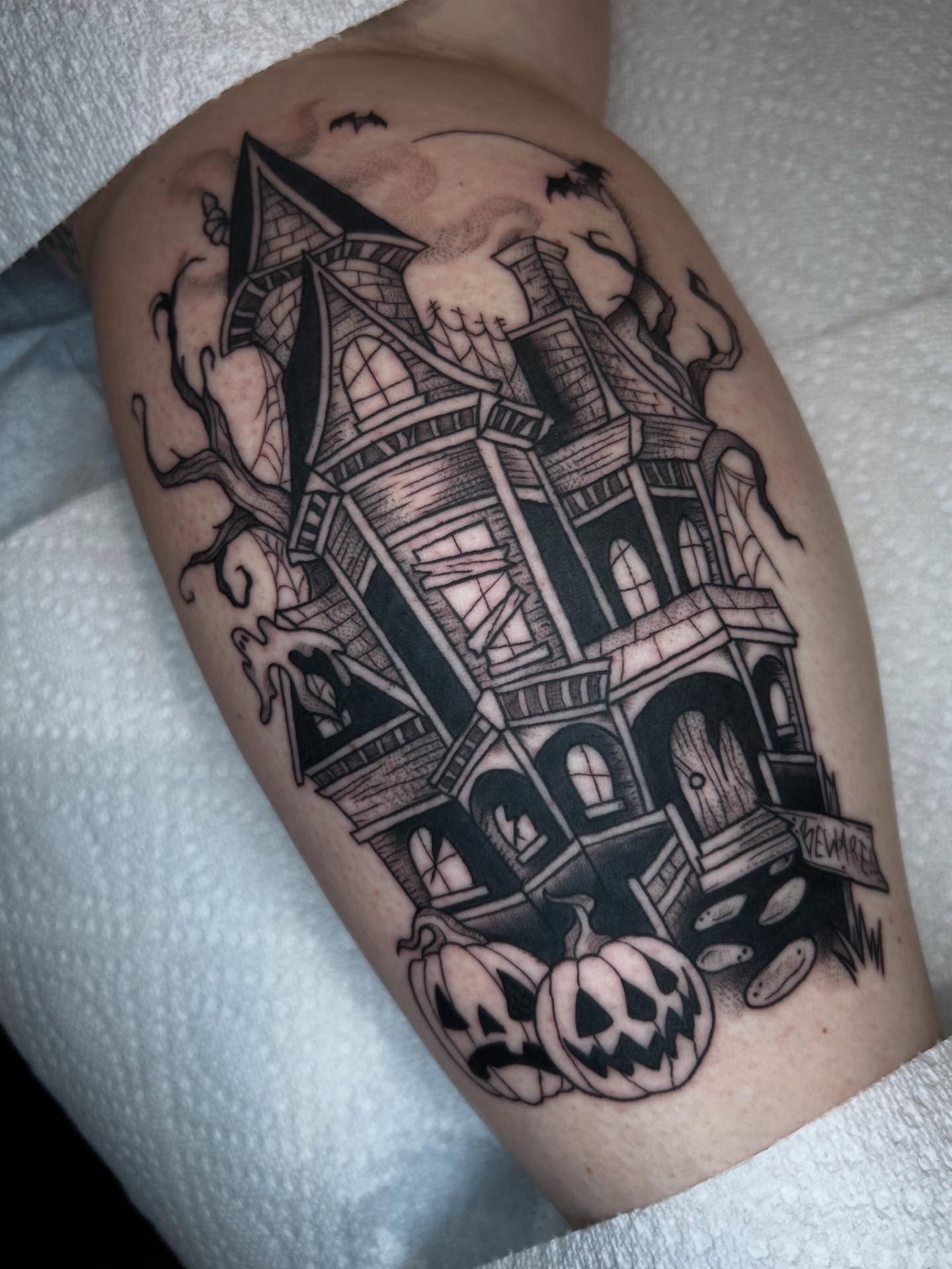 Haunted house black and grey tattoo on the thigh by Cassidy Hammer, Westland, Michigan