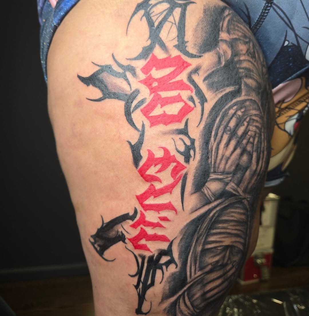 Script lettering and figure realism tattoo on the thigh by Lee Styles π¨