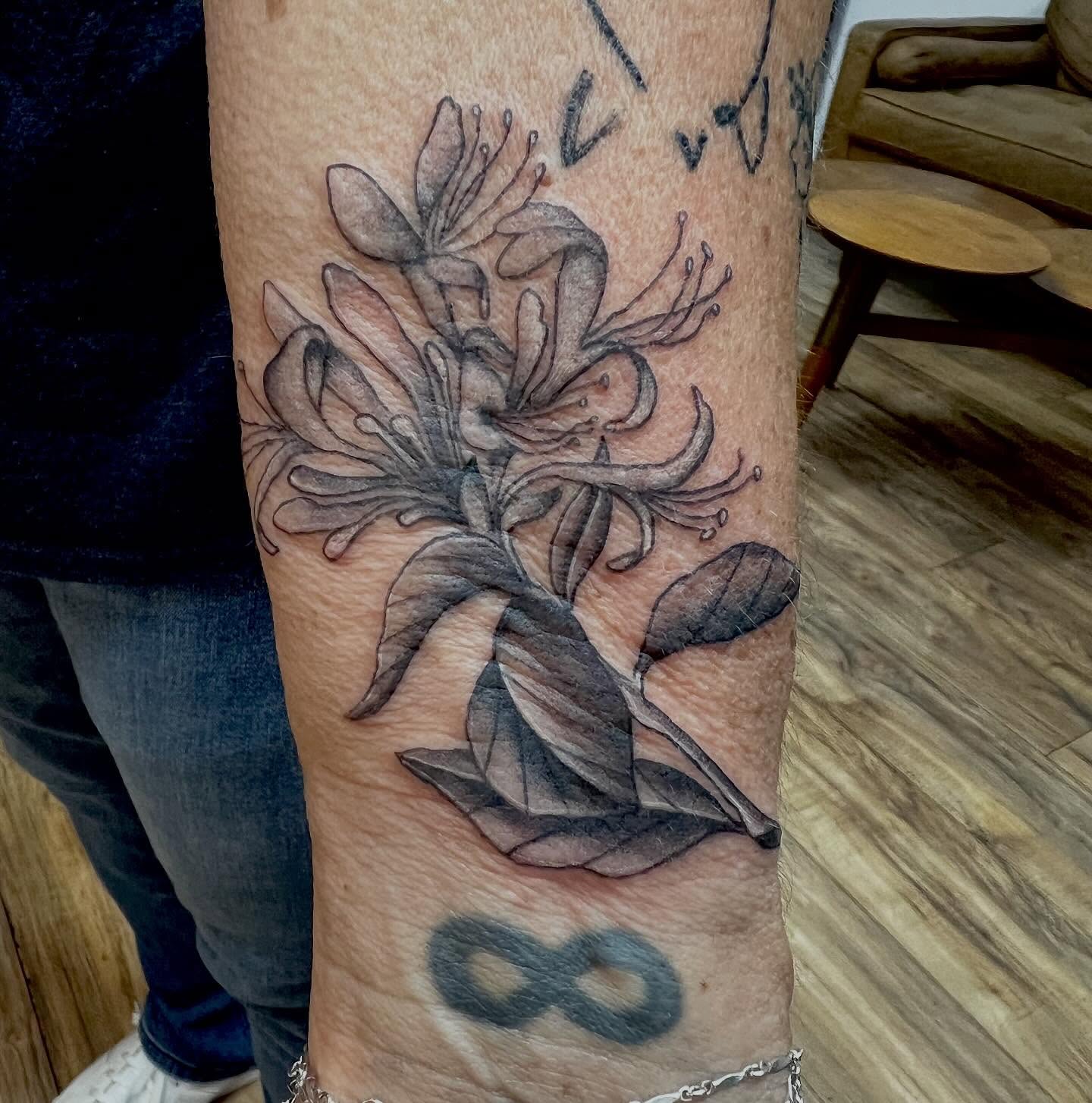 Lilies black and grey tattoo on the forearm by Victorian Coleman