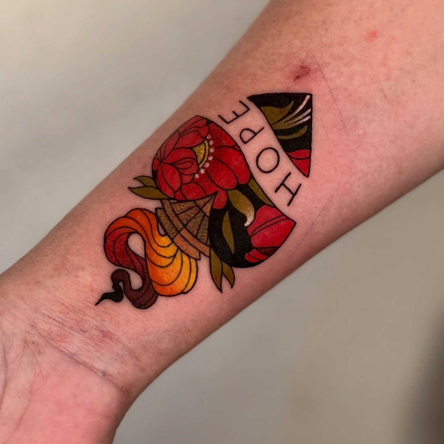 Flower and snake American traditional tattoo on the forearm by Jordan