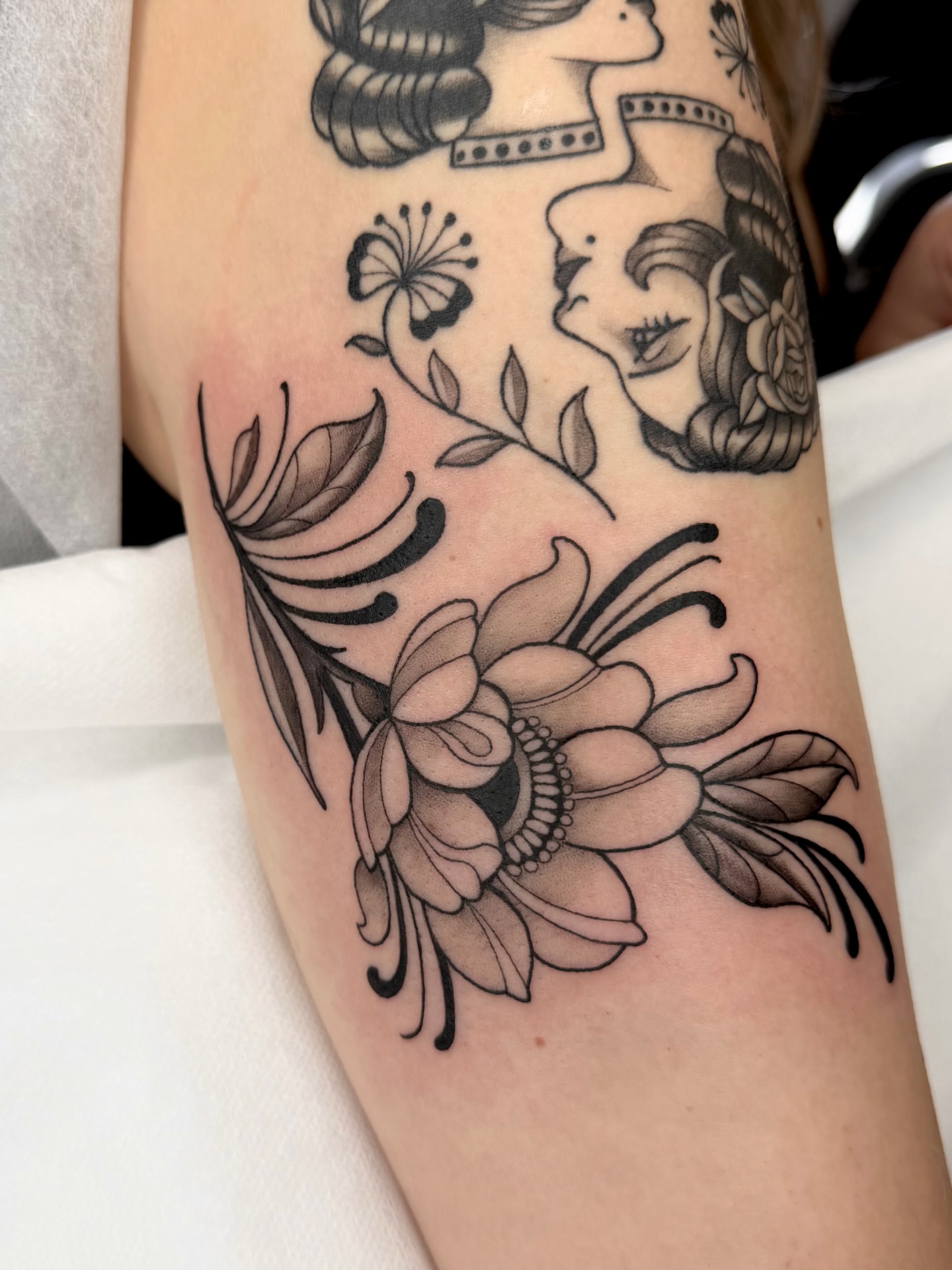 Floral design black and grey tattoo on the forearm by Red