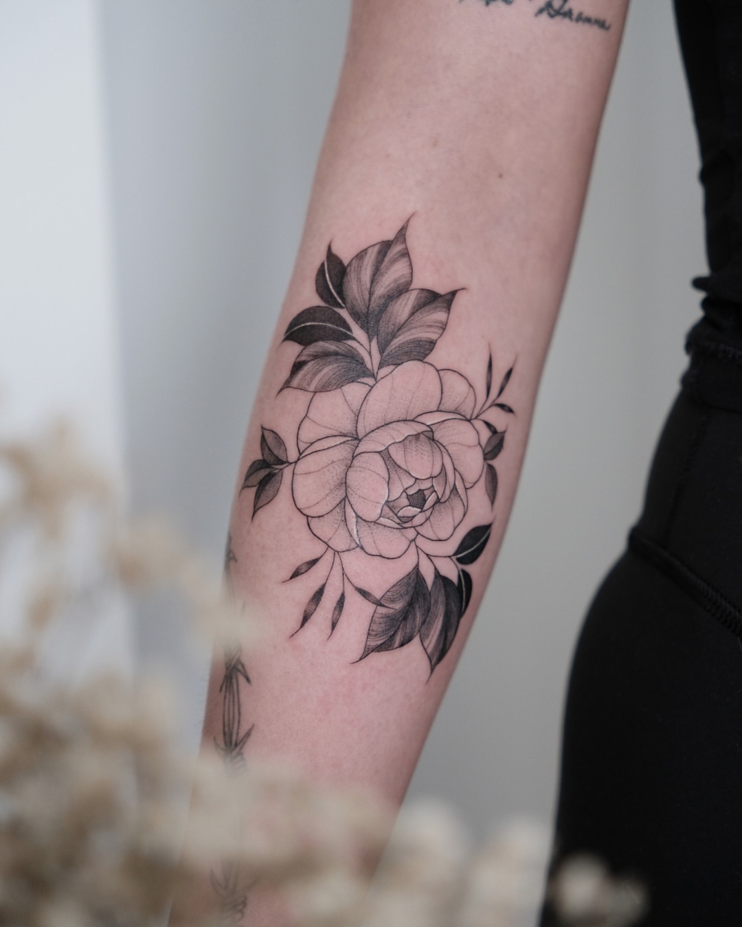 Flower black and grey tattoo on the forearm by Haley Sayers