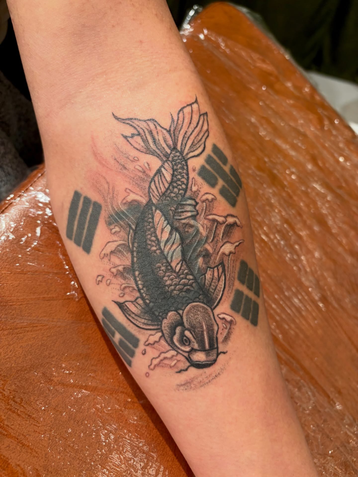 Koi fish black and grey tattoo on the forearm by Emily, Monticello, Iowa