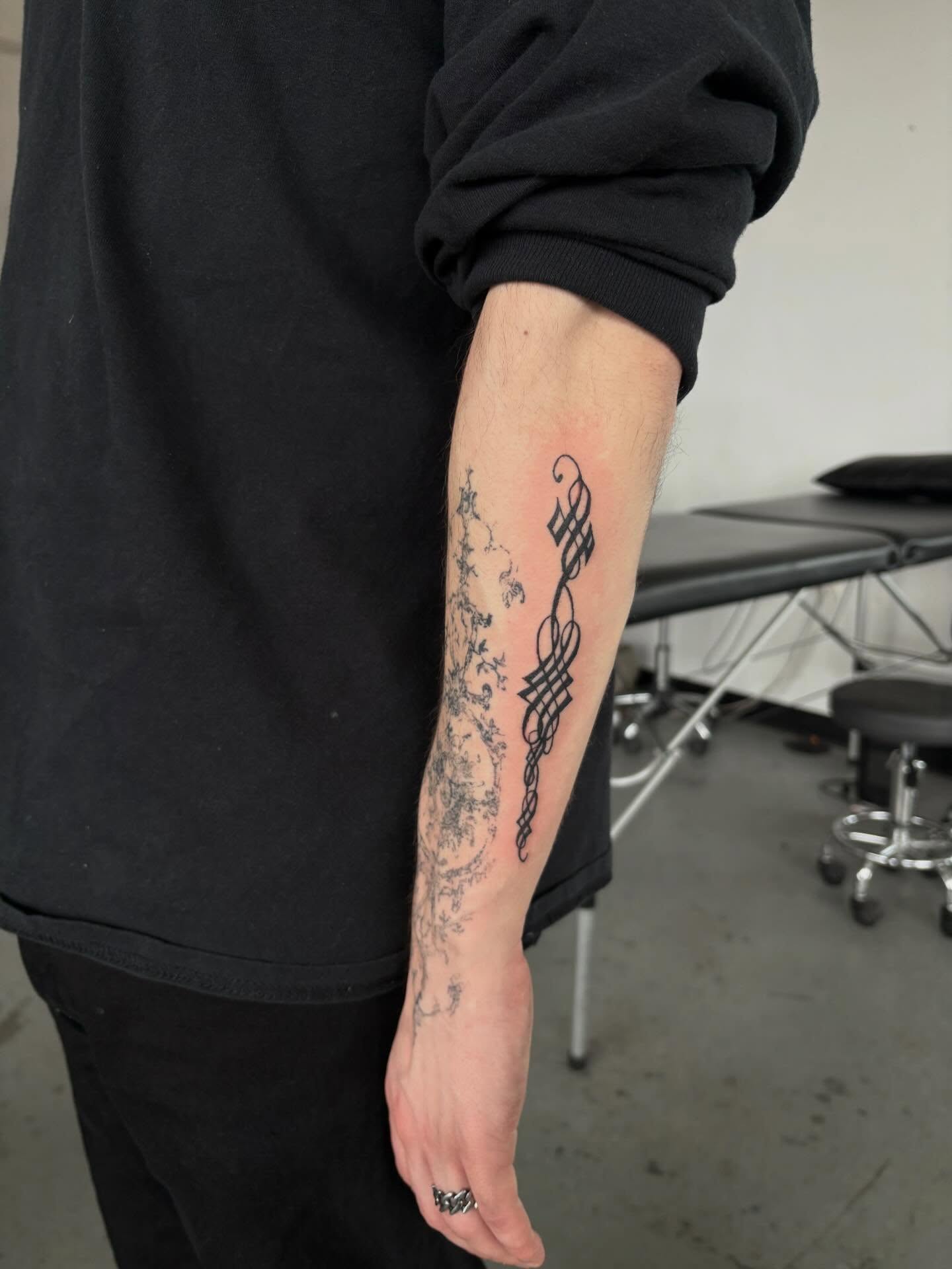 Scrollwork black and grey tattoo on the forearm by madeline