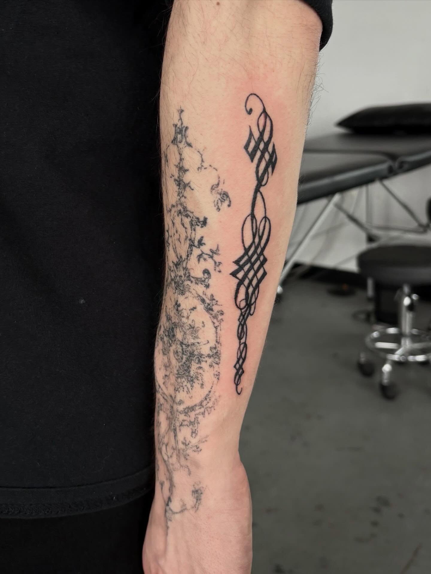 Scrollwork black and grey tattoo on the forearm by madeline