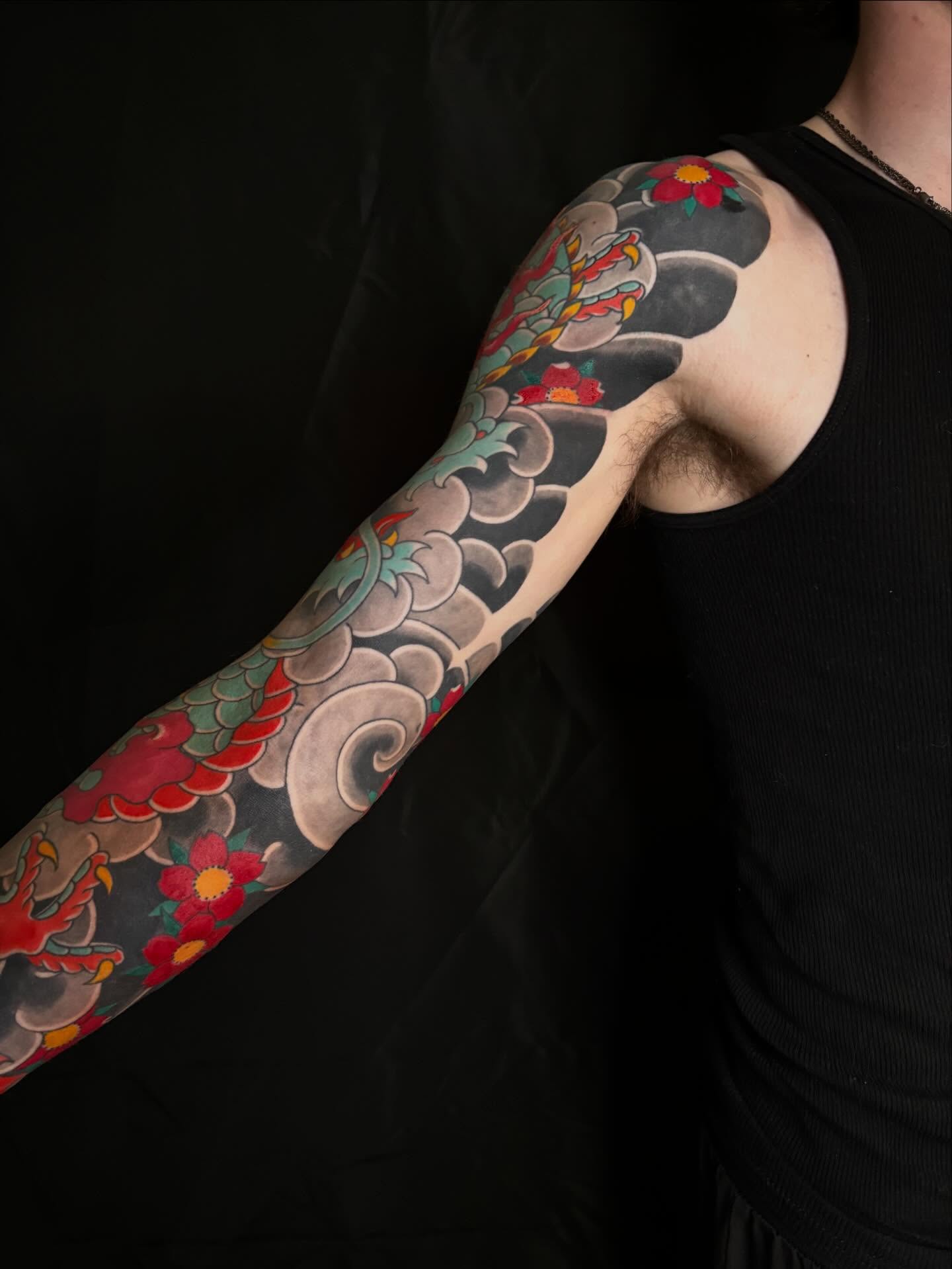 Floral and wave pattern japanese irezumi tattoo on the upper arm by Zach Hendrickson