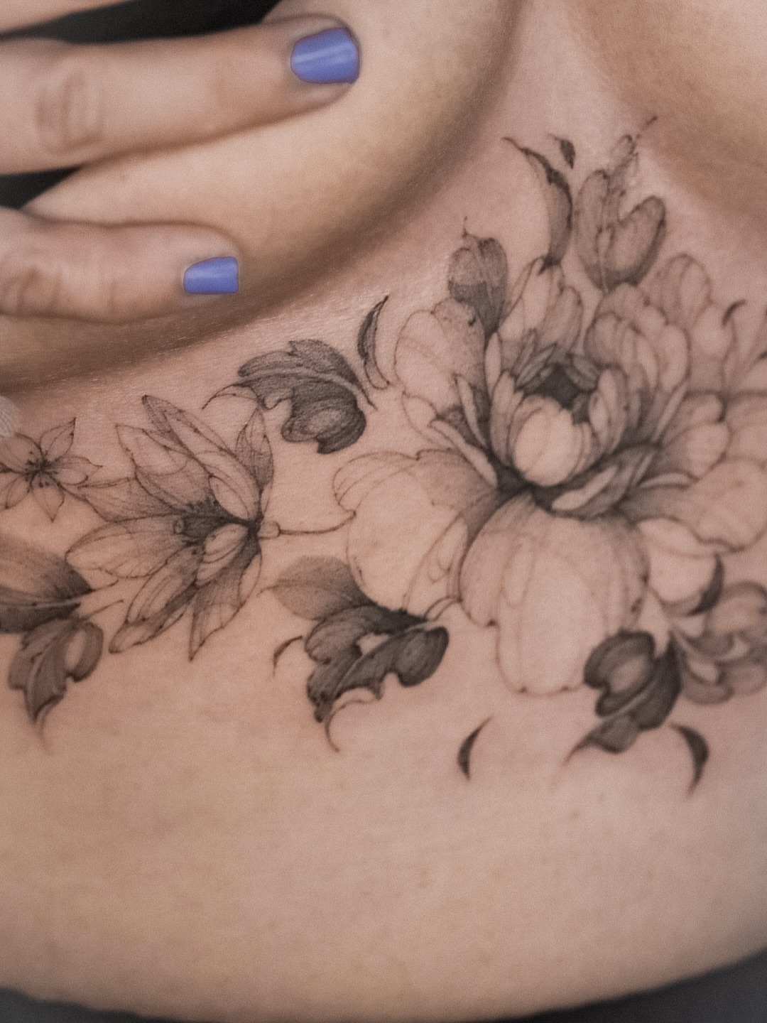 Floral arrangement black and grey tattoo on the chest by Maria