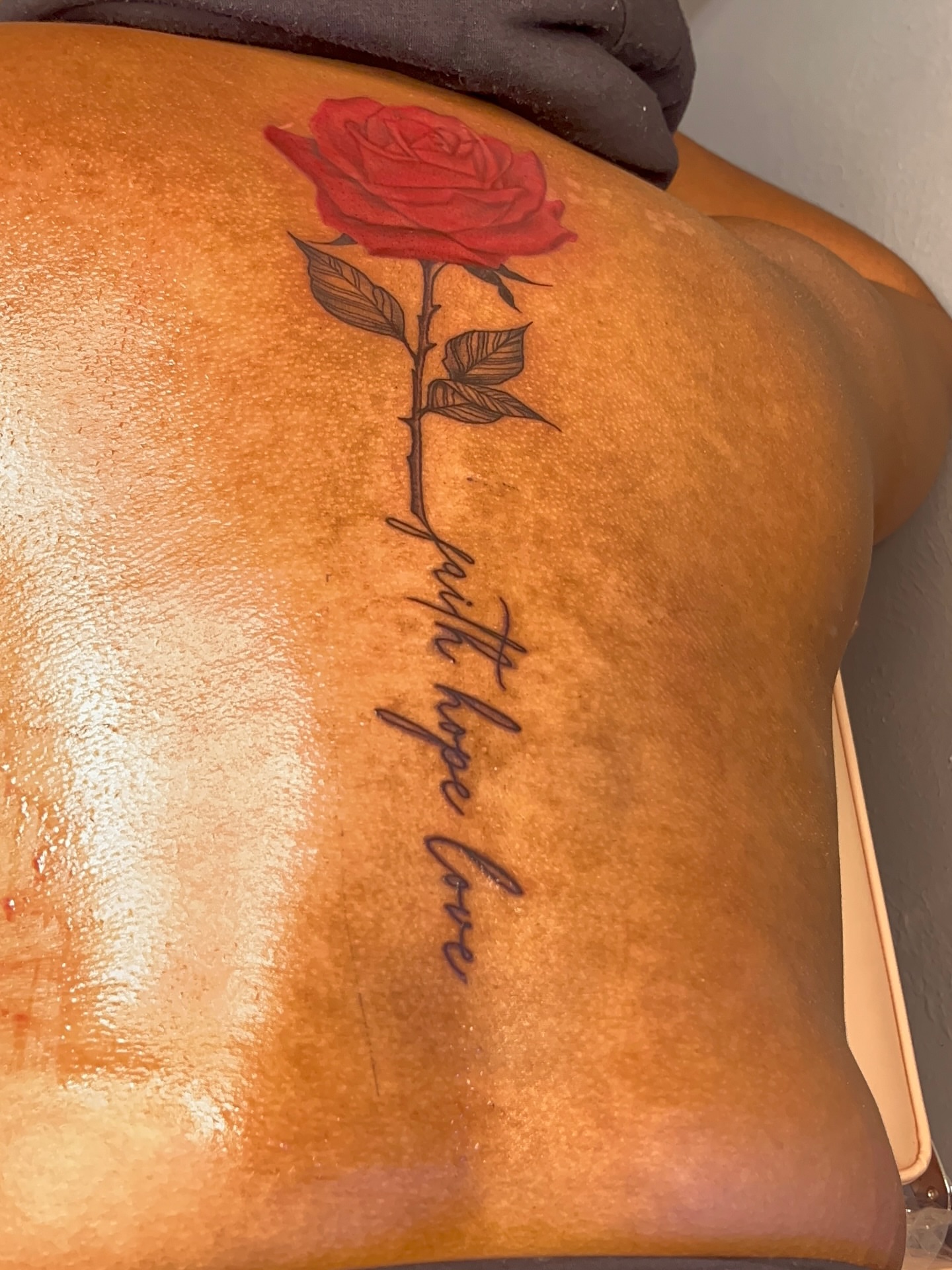 Red rose fine line tattoo on the back by The inspo