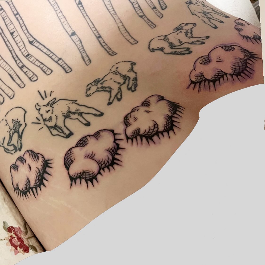 Sheep and clouds black and grey tattoo on the upper arm by ren