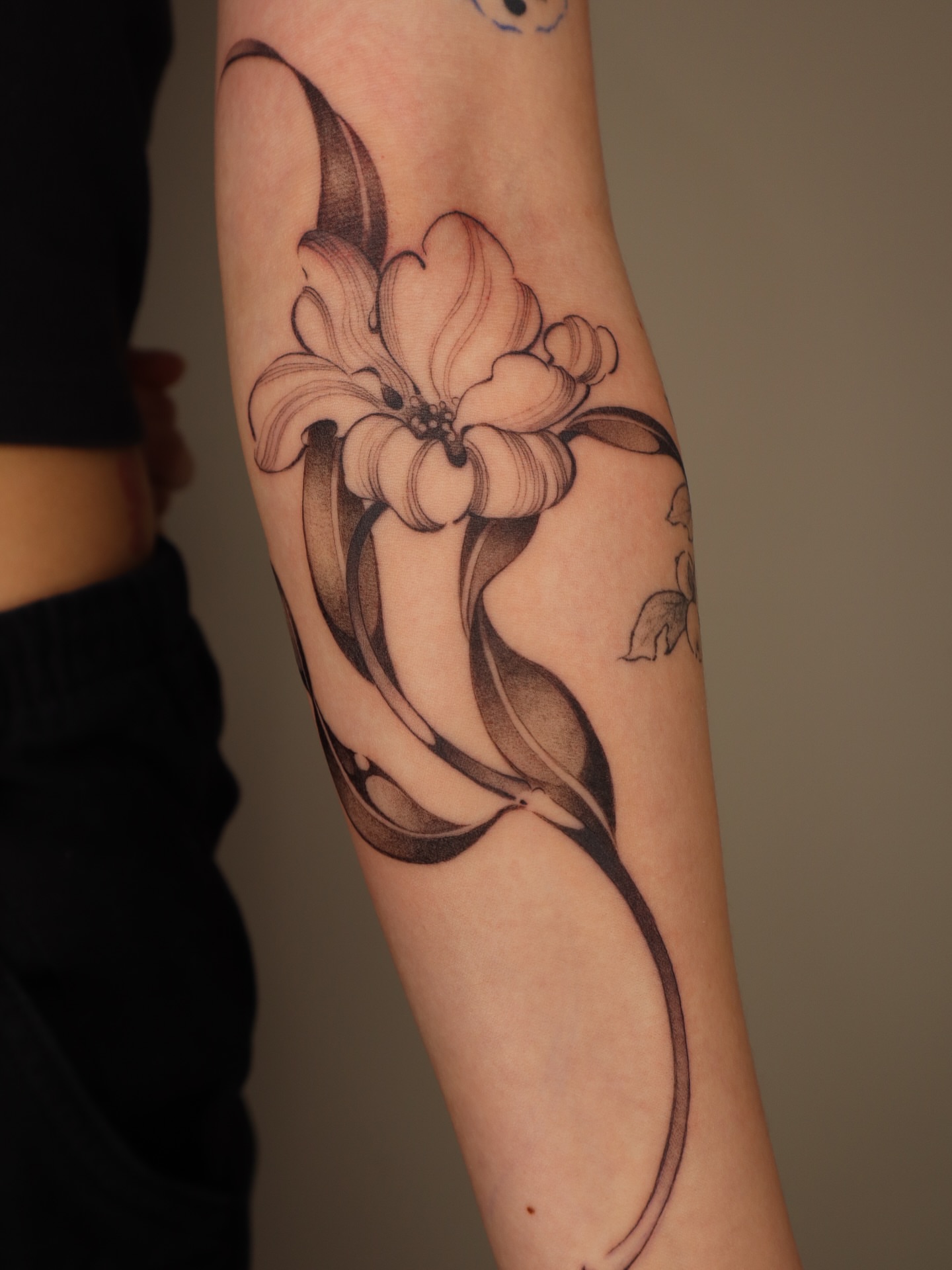 Lily black and grey tattoo on the forearm by Savana Wang