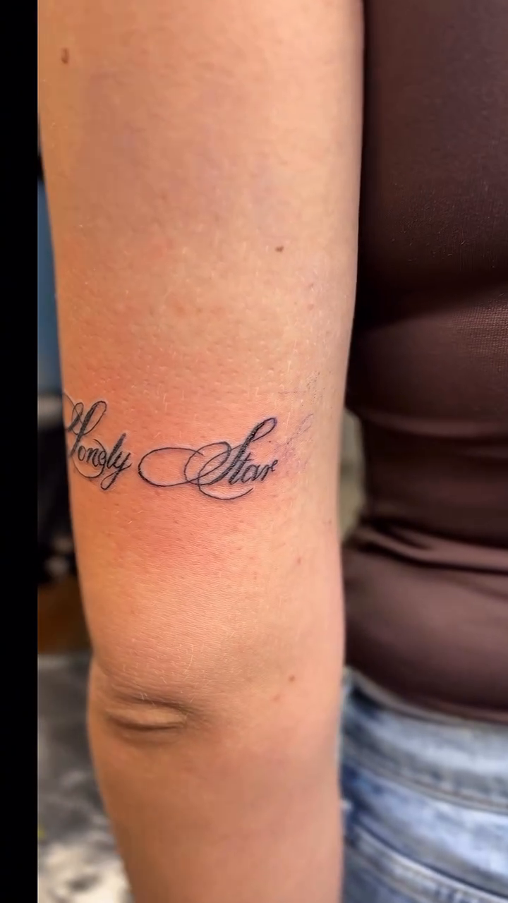 Script tattoo on arm lettering tattoo on the upper arm by Jason Topliss