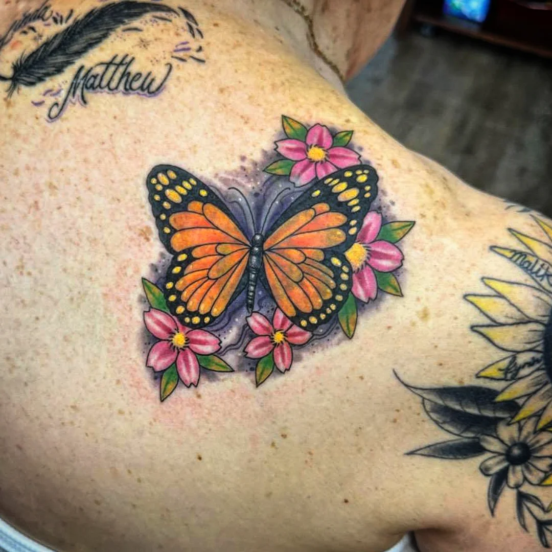 Butterfly and flowers American traditional tattoo on the shoulder by Josh Sroga