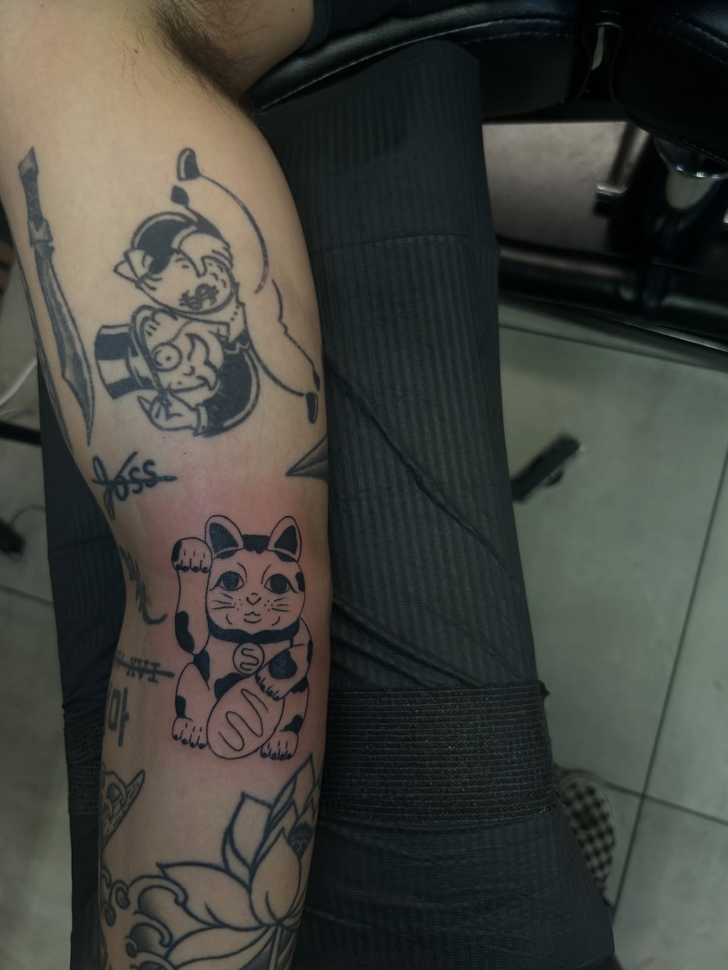 Cat and dog black and grey tattoo on the forearm by Torrey, Austin, Texas