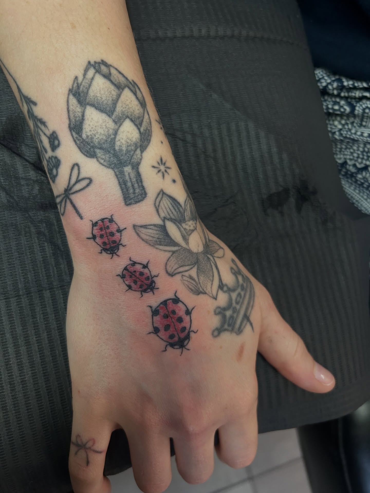 Ladybugs and lotus dotwork tattoo on the forearm by Torrey, Austin, Texas