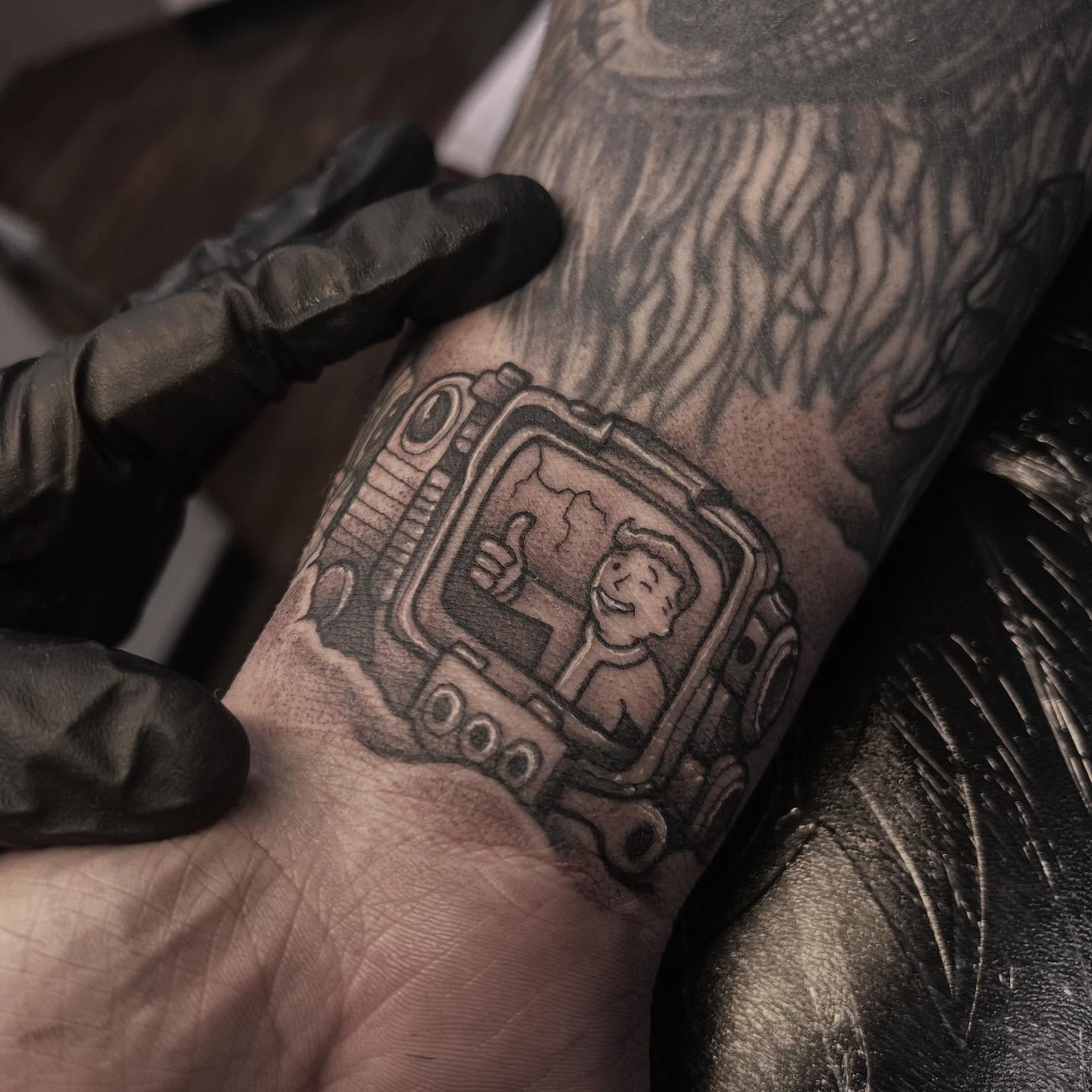 Radio with character black and grey tattoo on the forearm by Sarah Foltz