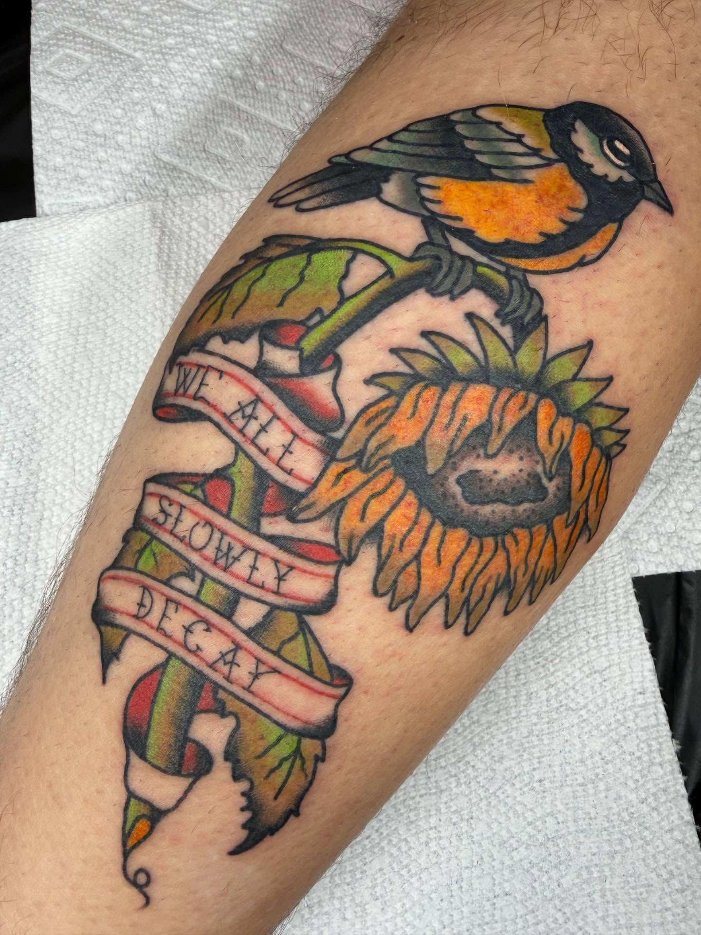 Sunflower and bird American traditional tattoo on the forearm by April Morris ⚔️ Tattoo Goblin