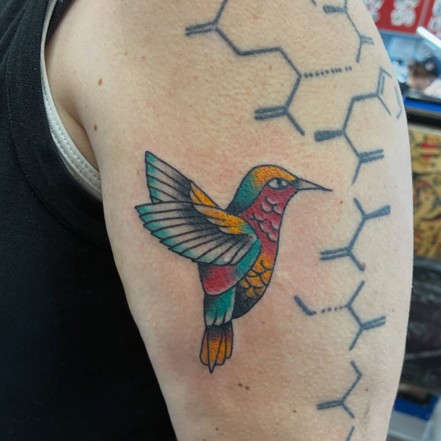 Hummingbird new school tattoo on the upper arm by Kennedy Cole