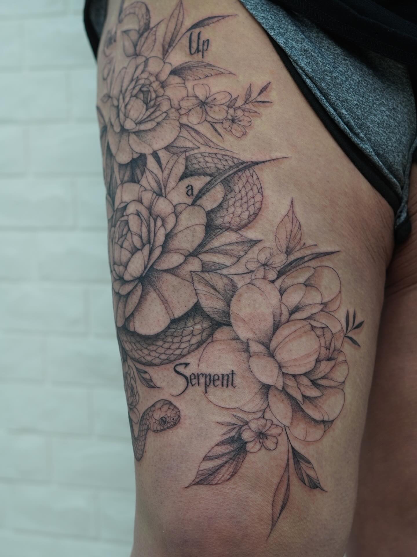 Snake and peony realism tattoo on the thigh by Danae Andino