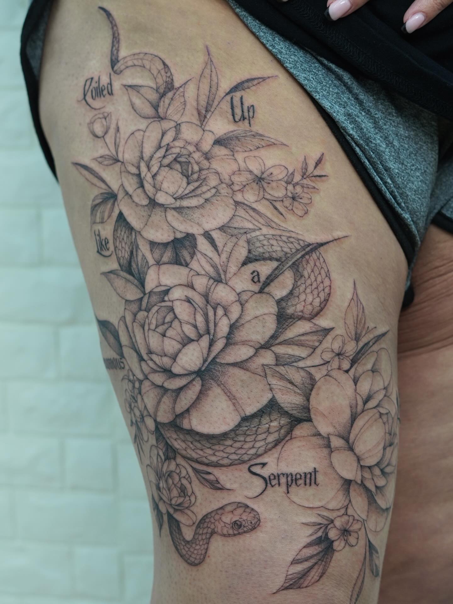 Snake and peony realism tattoo on the thigh by Danae Andino