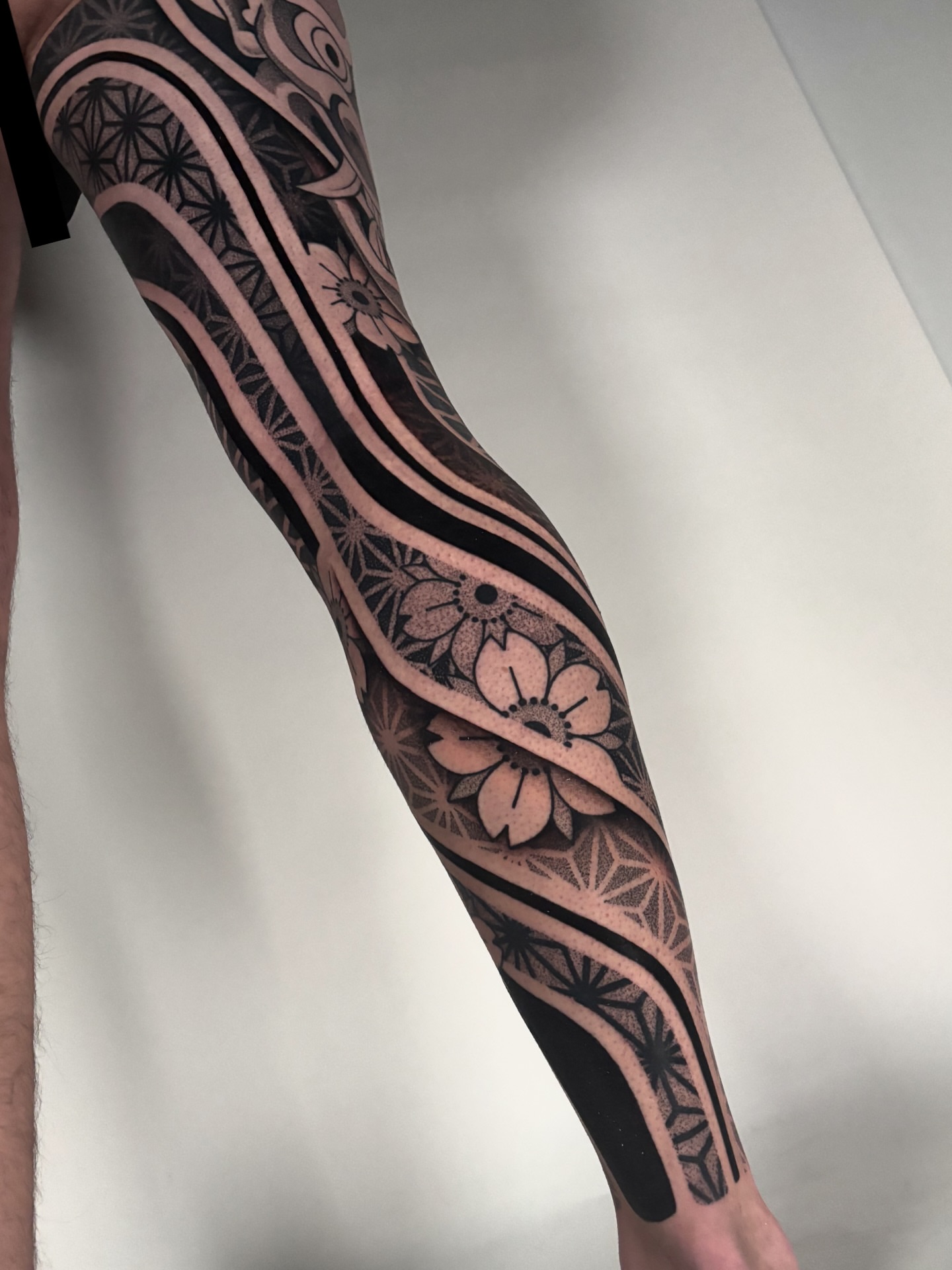 Floral pattern geometric tattoo on the forearm by Mitch Koch