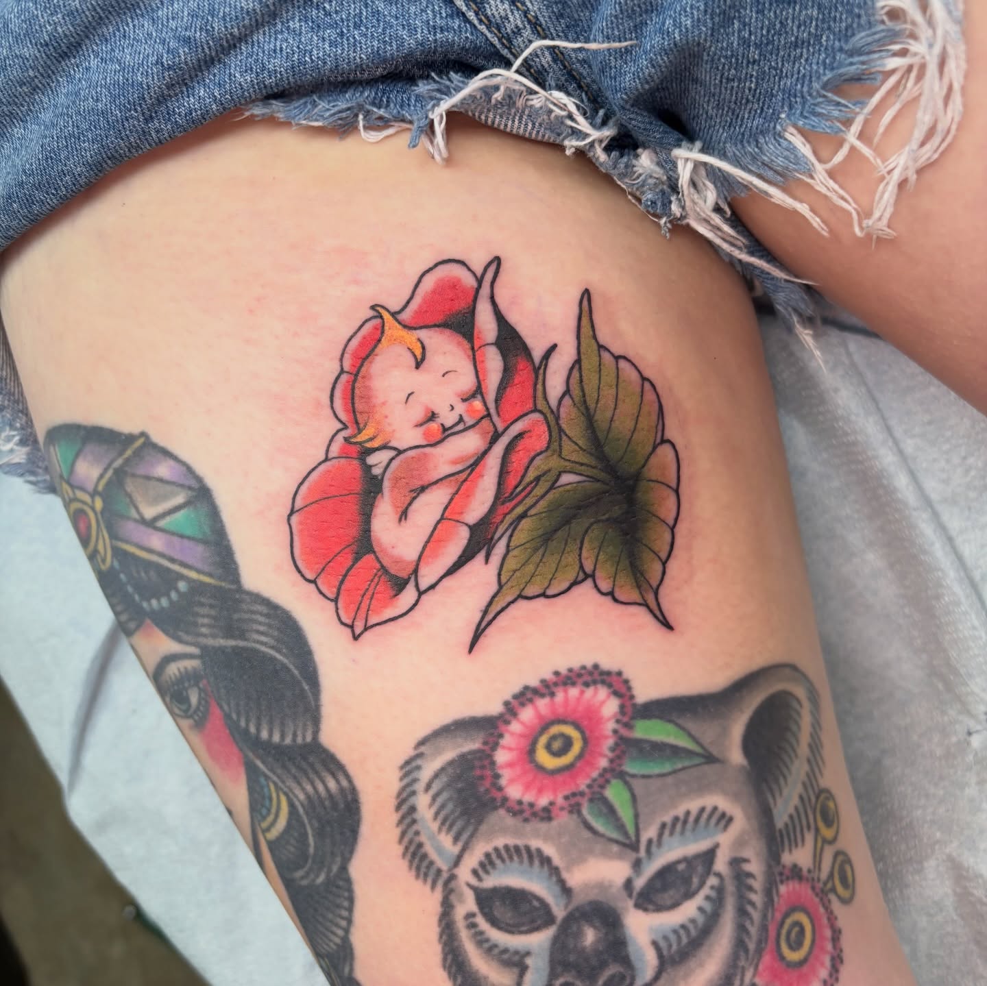 Baby in flower American traditional tattoo on the thigh by 𝙻𝙰𝙼𝚈𝙰 (𝙻𝙴𝙼-𝚈𝙰) 𝚂𝙰𝚄𝙽𝙳𝙴𝚁𝚂