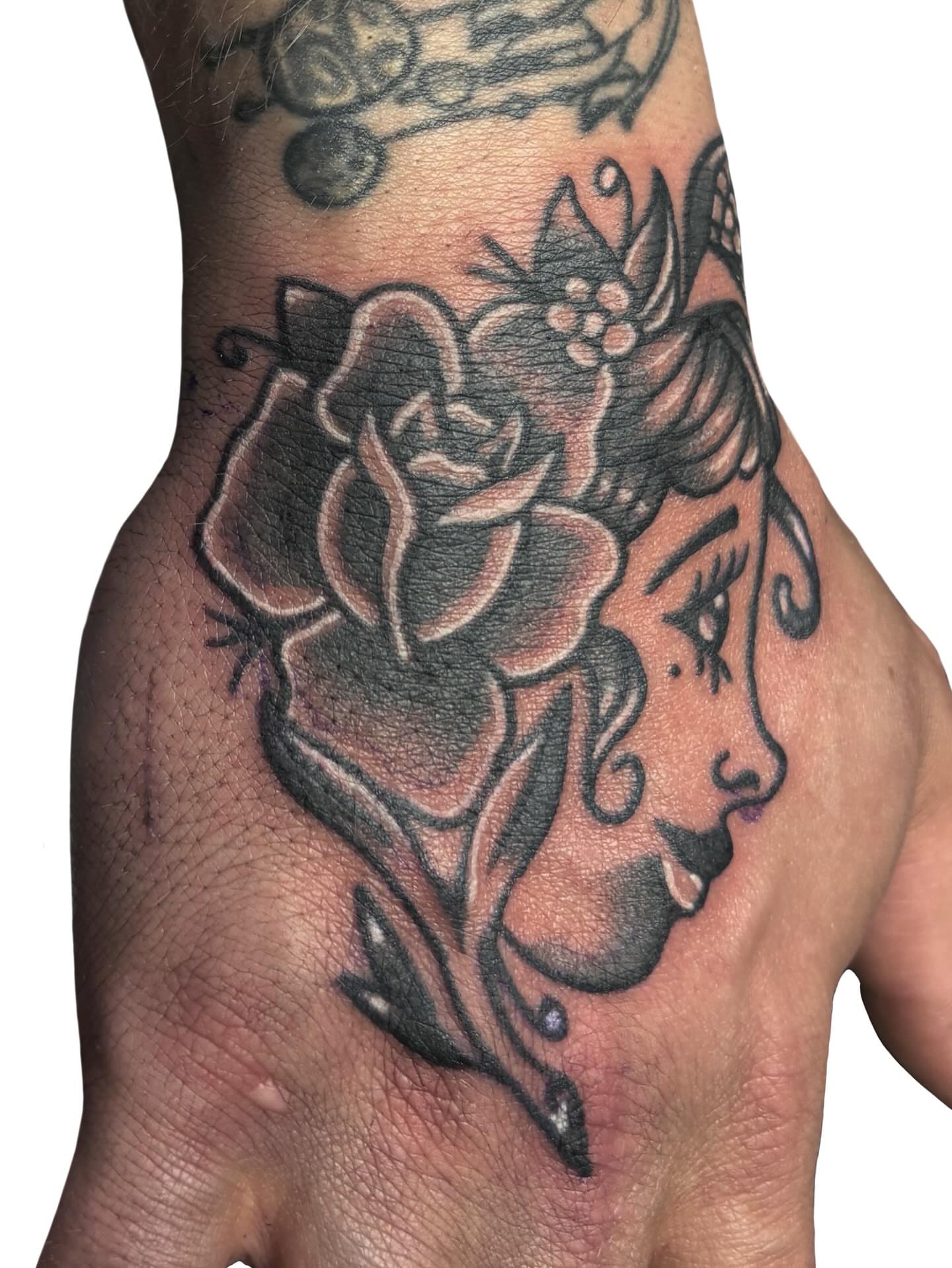 Woman with rose American traditional tattoo on the hand by Ava Brady Tattoos