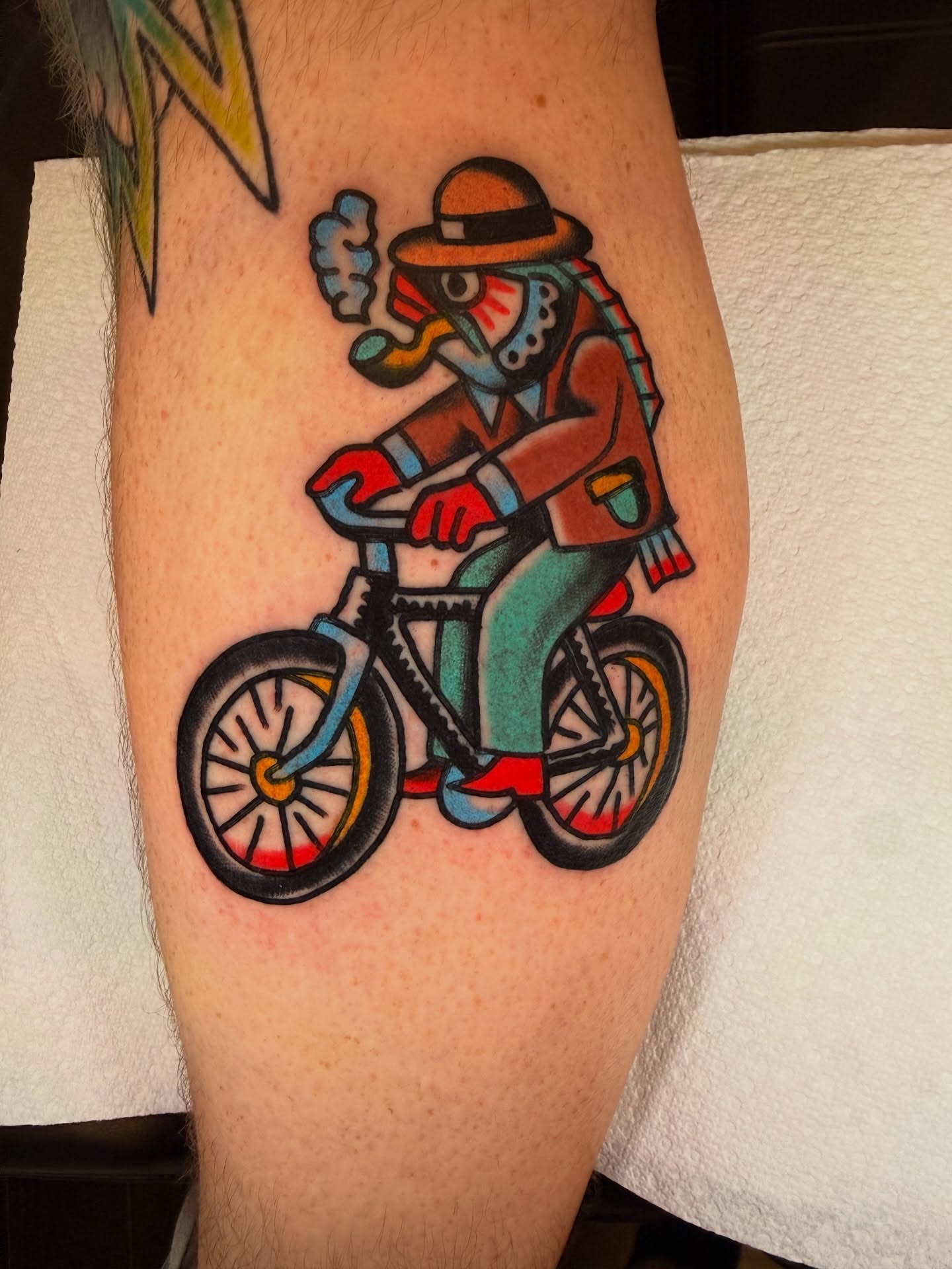 Rider on bicycle American traditional tattoo on the leg by {{Theo Glanton}}
