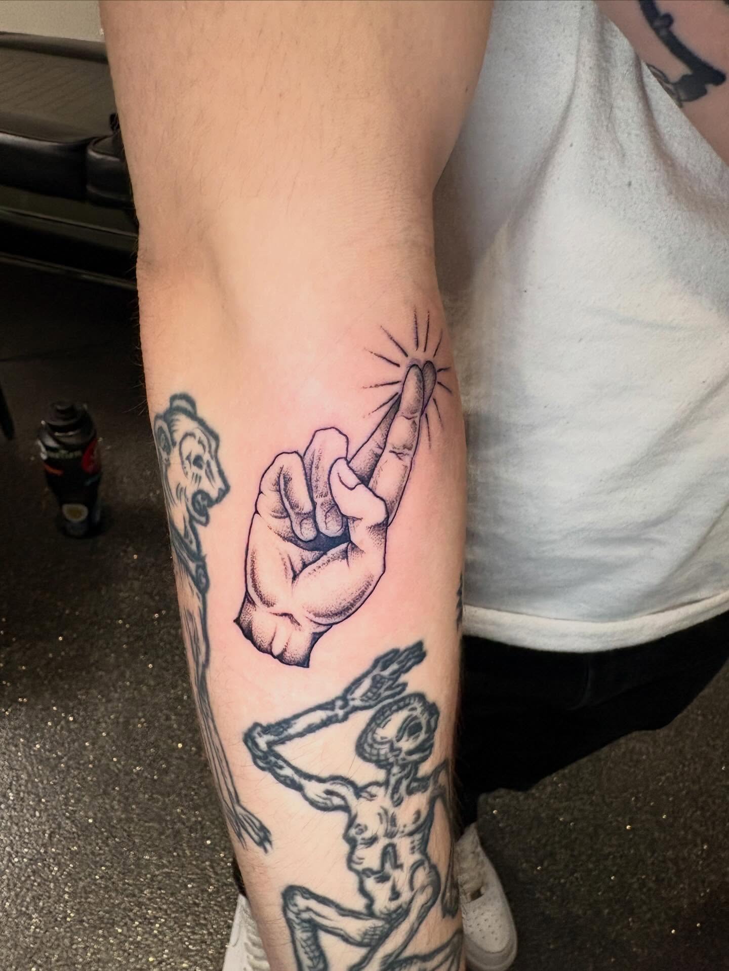 Middle finger gesture American traditional tattoo on the forearm by Eddie Wolfe