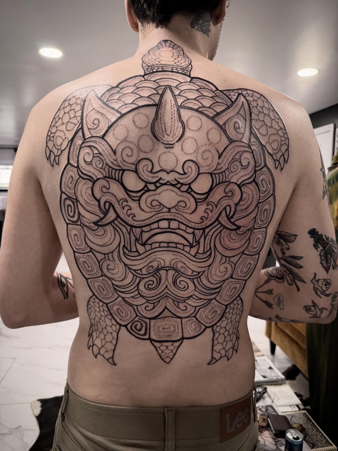 Lion mask black and grey tattoo on the back by Shannon Misitano