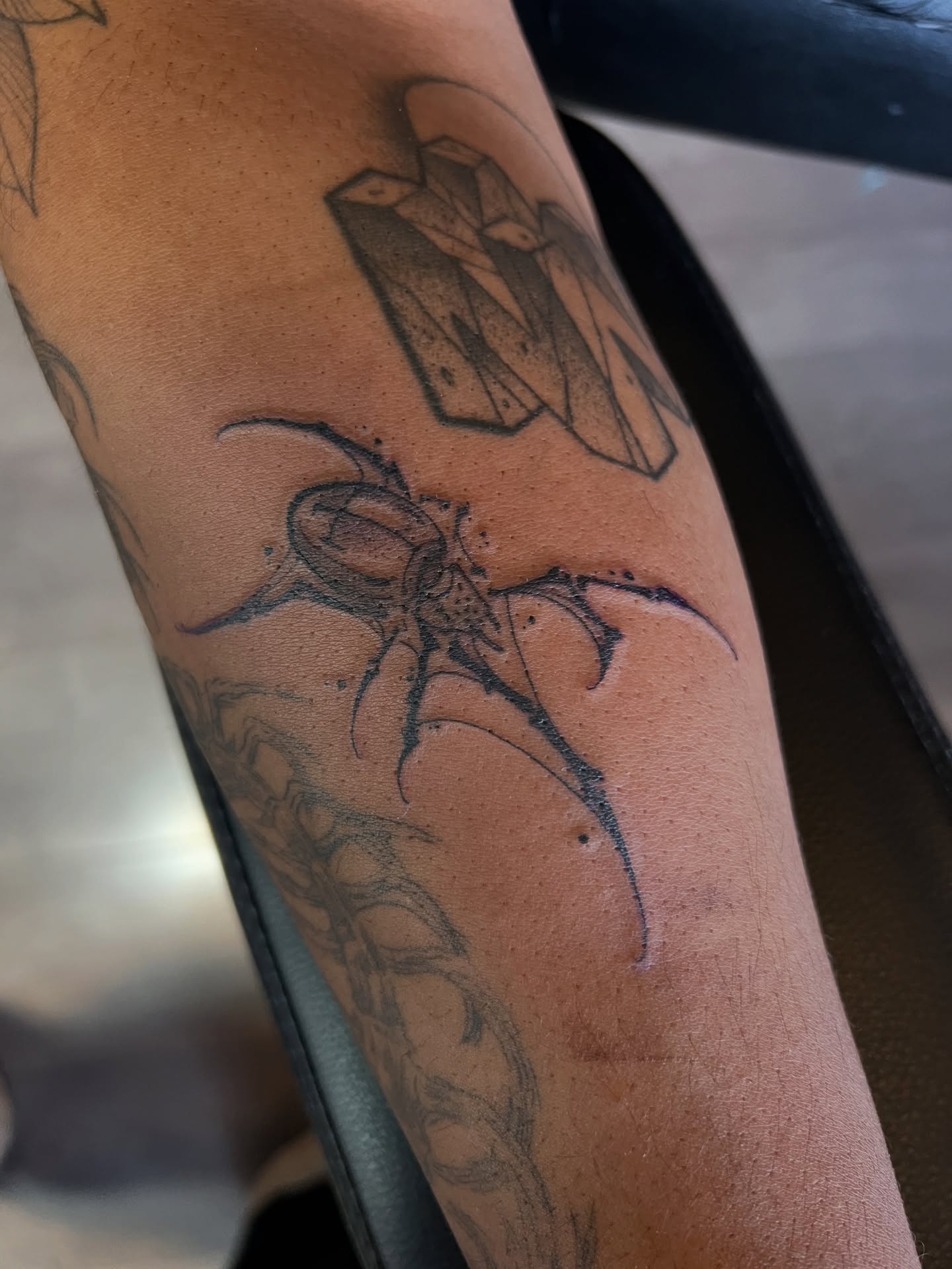 Spider black and grey tattoo on the forearm by Owen Smith -OEOS- SF