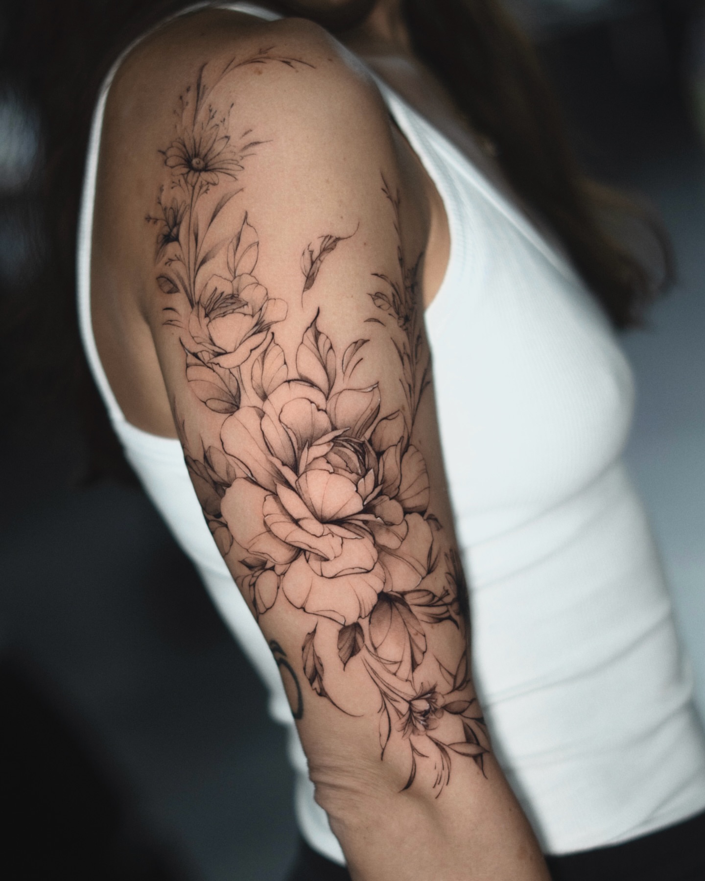 Floral bouquet black and grey tattoo on the upper arm by Ron Alvarez